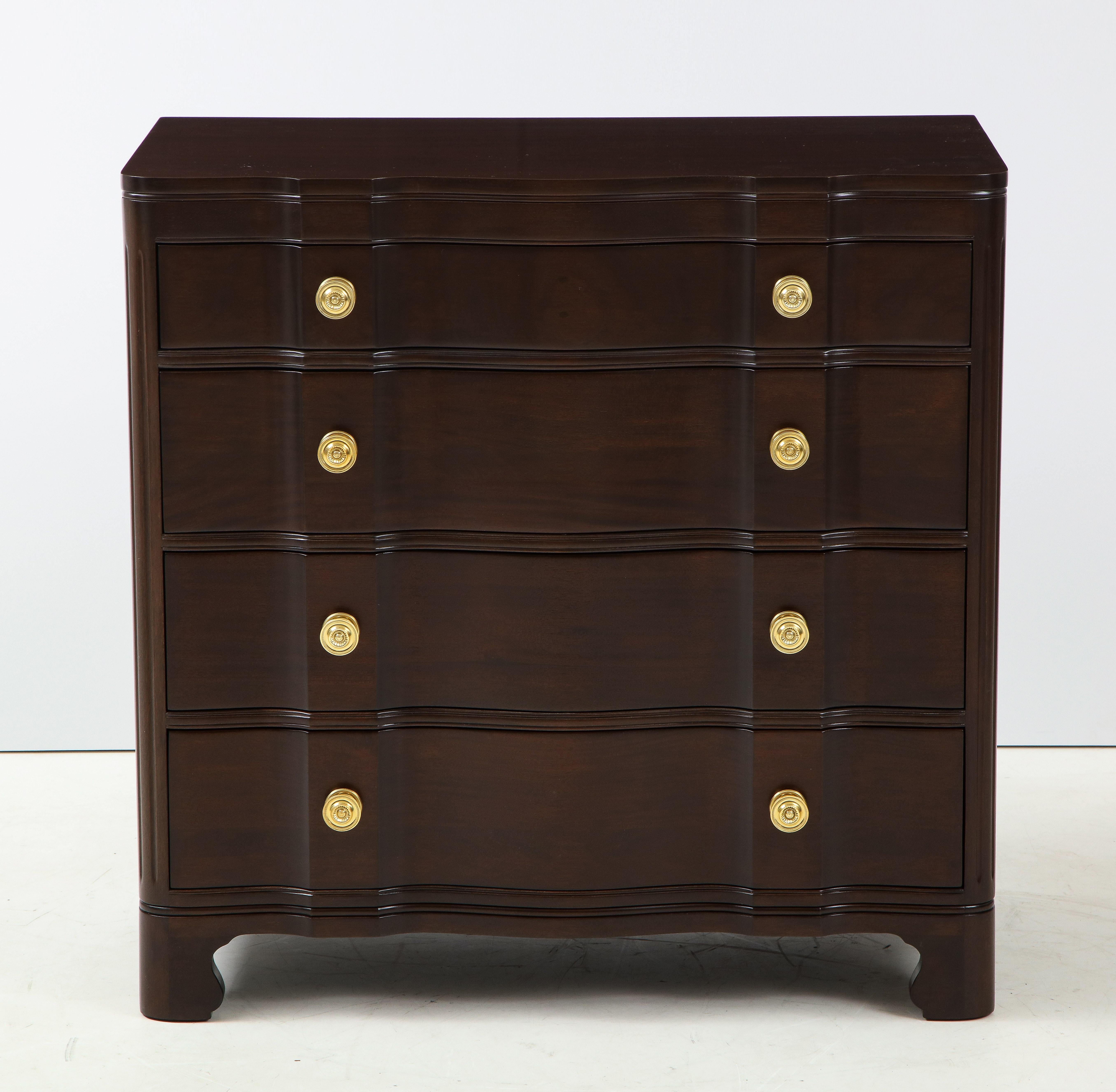 Elegant pair of neoclassical meets midcentury mahogany chest of drawers with a sinuous front and featuring 4 ample drawers each with detailed brass pulls. Restored with a satin finish. Signed.