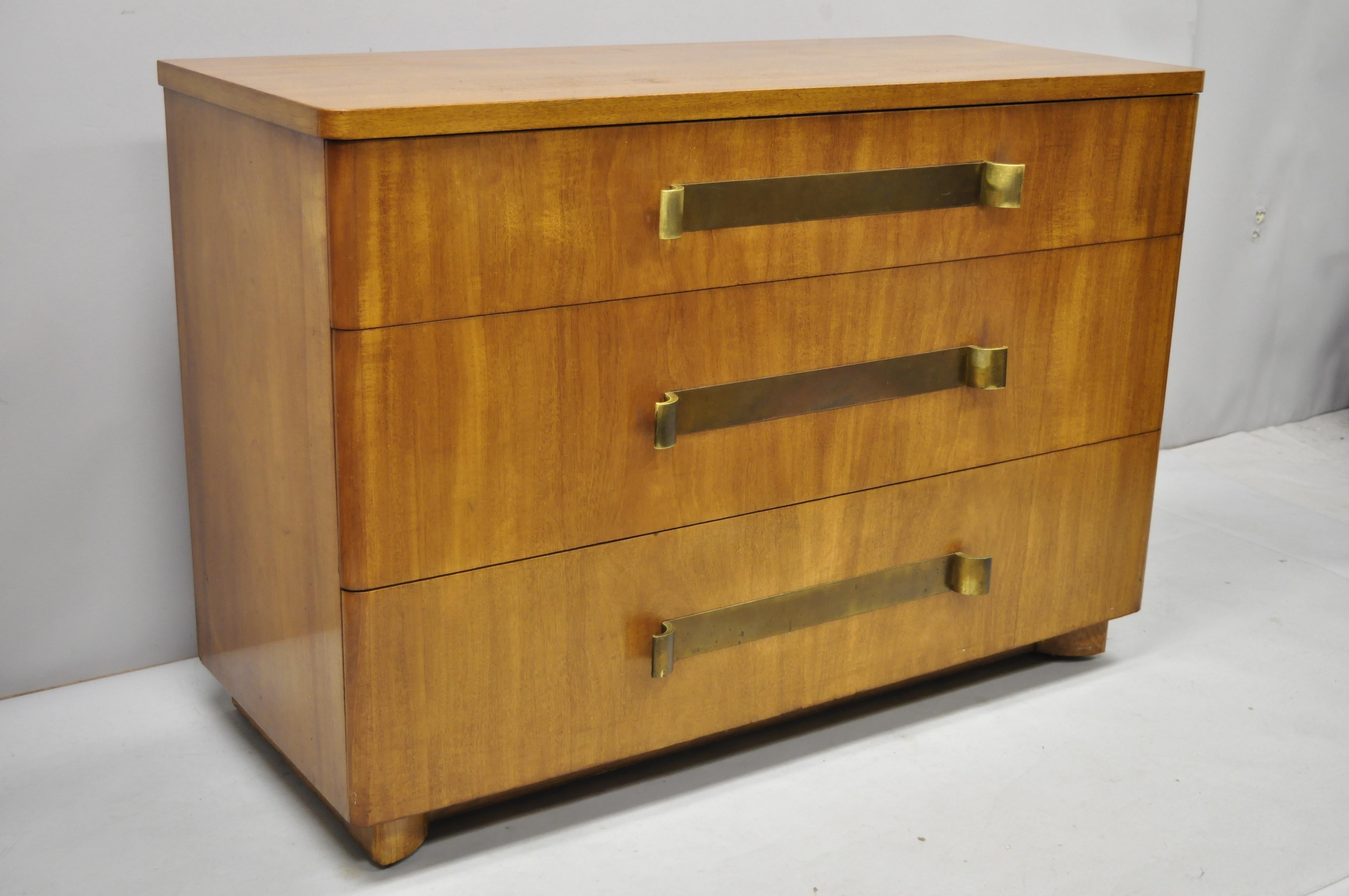 John Stuart Mid-Century Modern Art Deco birch dresser with sculpted bronze pulls. Listing includes. bronze/brass drawer pulls with wonderful patina, rolling casters, beautiful wood grain, original label, 3 drawers, clean modernist lines, quality