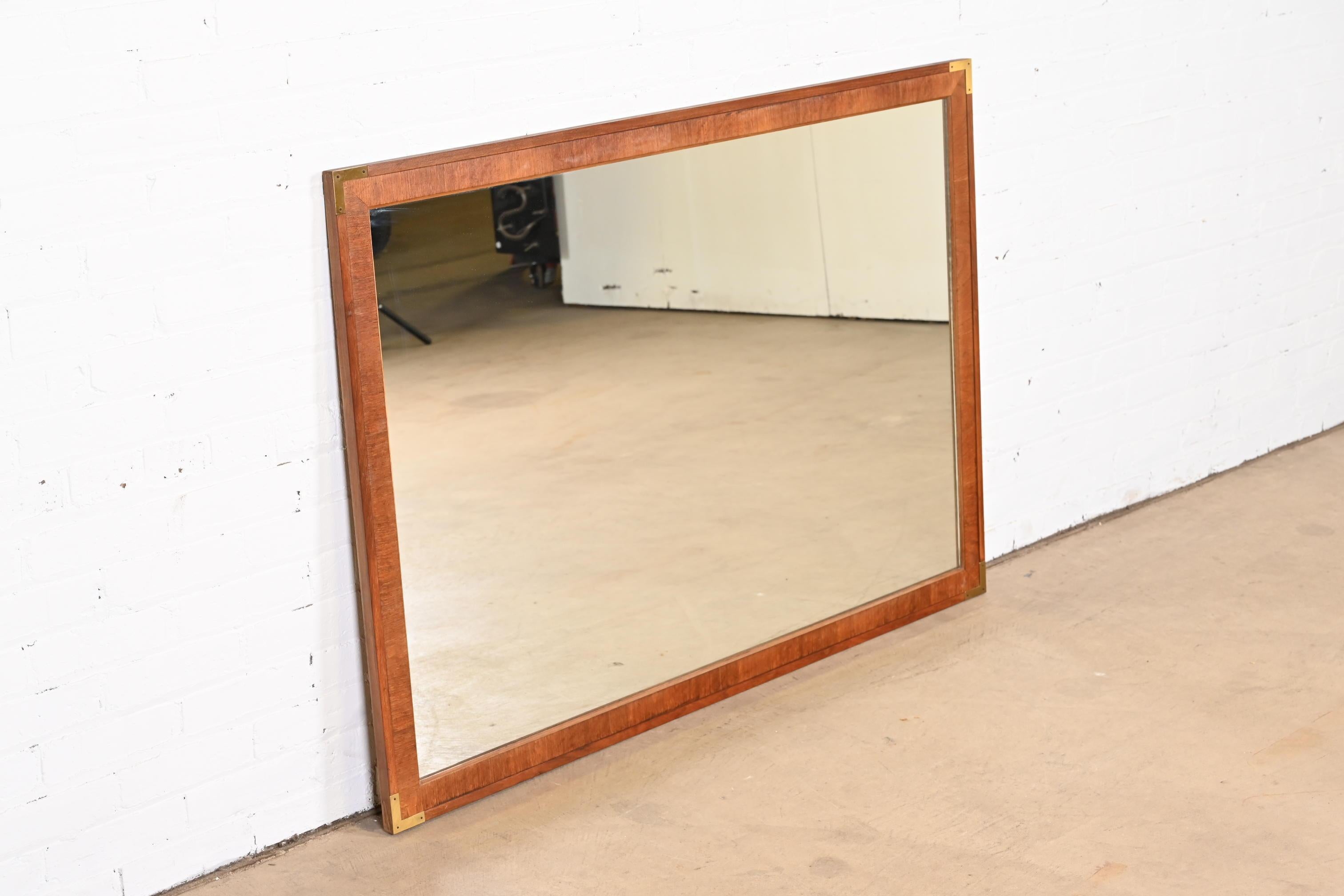 A stylish Mid-Century Modern Campaign style walnut and brass framed wall mirror

By John Stuart

USA, 1960s

Measures: 52.38