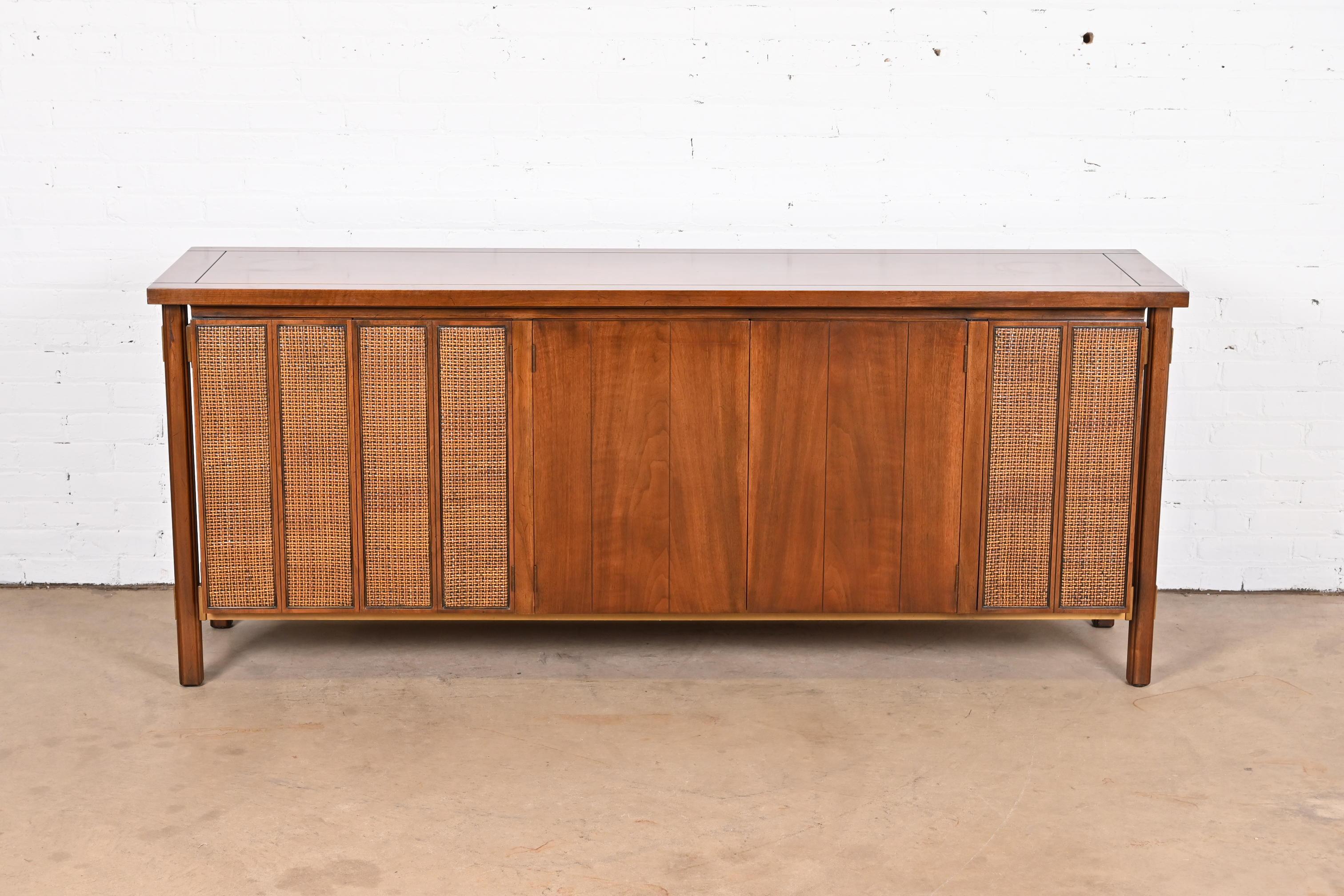 A gorgeous Mid-Century Modern sideboard, credenza, or bar cabinet.

By John Stuart.

USA, Circa 1960s.

Walnut, with caned panels and brass accents.

Measures: 78
