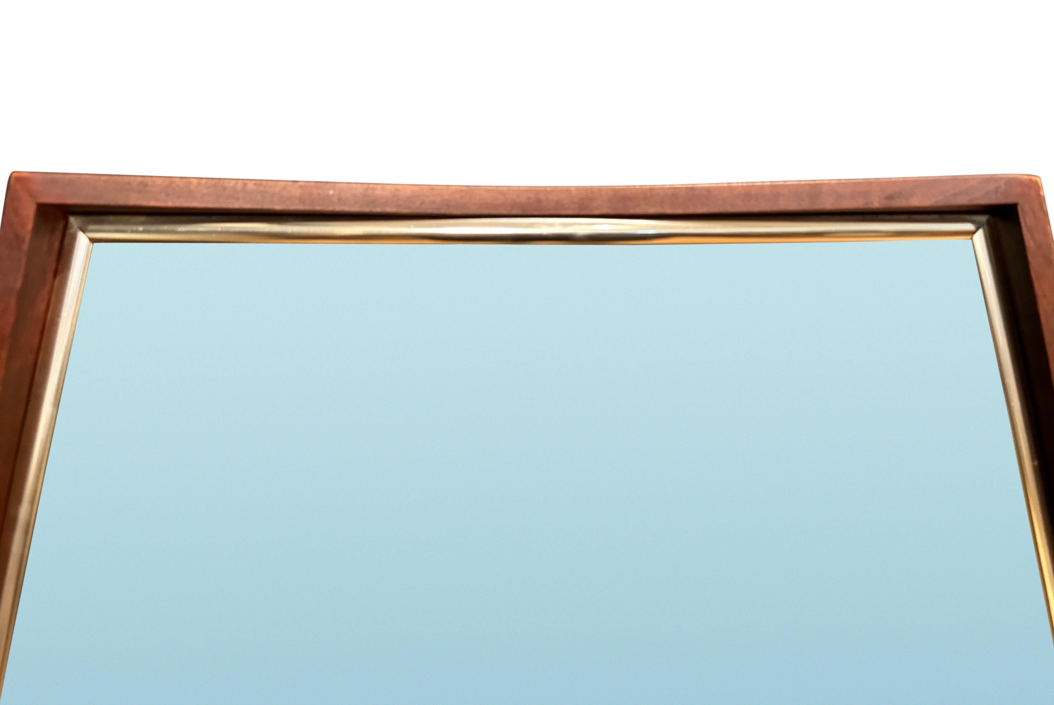Bello specchio in noce della linea sottile del Mid Century Modern. All'interno è rifinito con una sottile modanatura in ottone. Forma delicatamente curva con interni leggermente più profondi in alto e in basso.