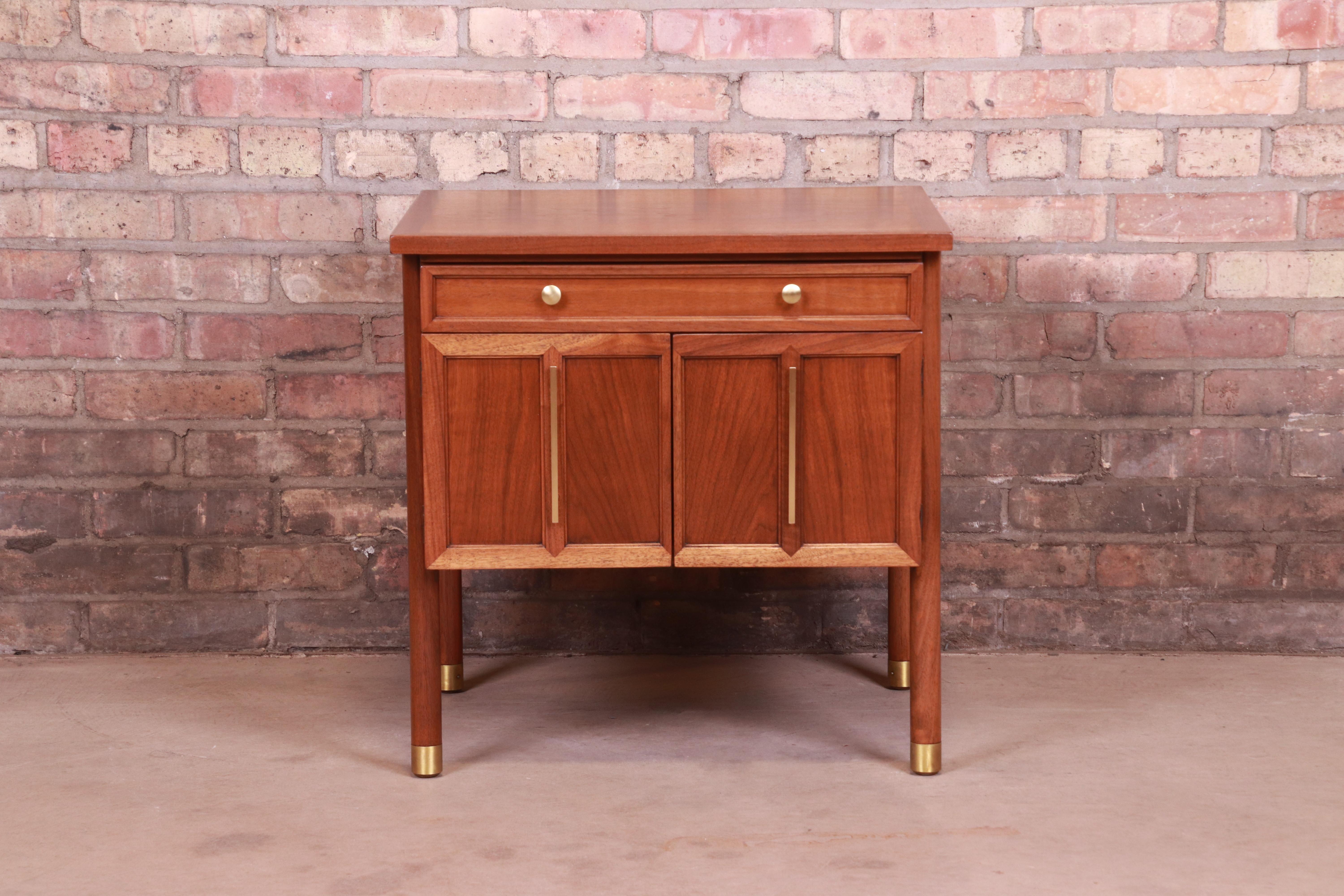 A gorgeous Mid-Century Modern nightstand or occasional side table

By John Stuart

USA, circa 1960s

Book-matched walnut, with original brass hardware and brass-capped feet.

Measures: 22