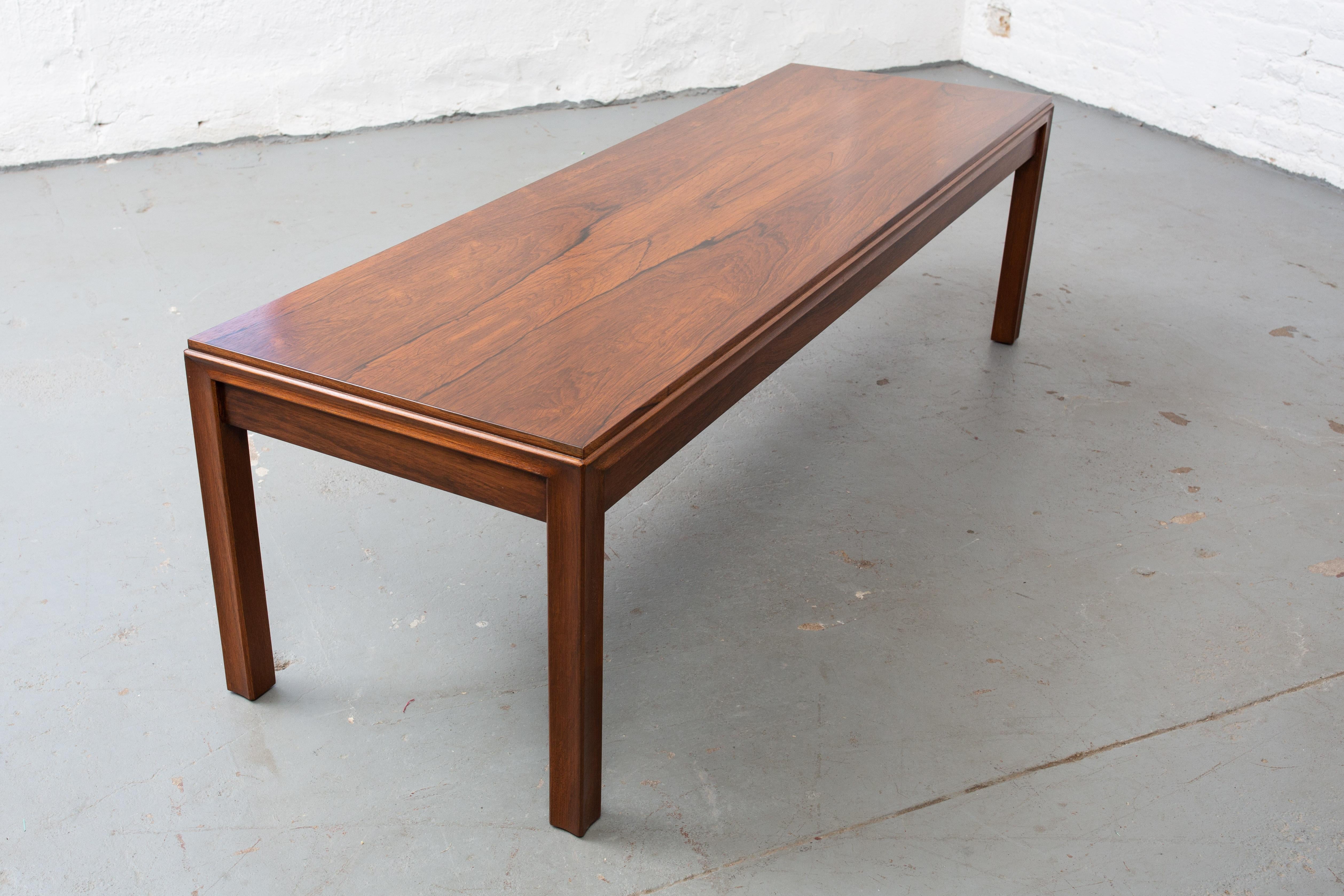 Beautiful rosewood coffee table with spectacular original finish. Legs have a curved details similar to the Janus collection but different and unique. Exceptional craftsmanship, beautiful grain and a great size. Stamped and numbered 