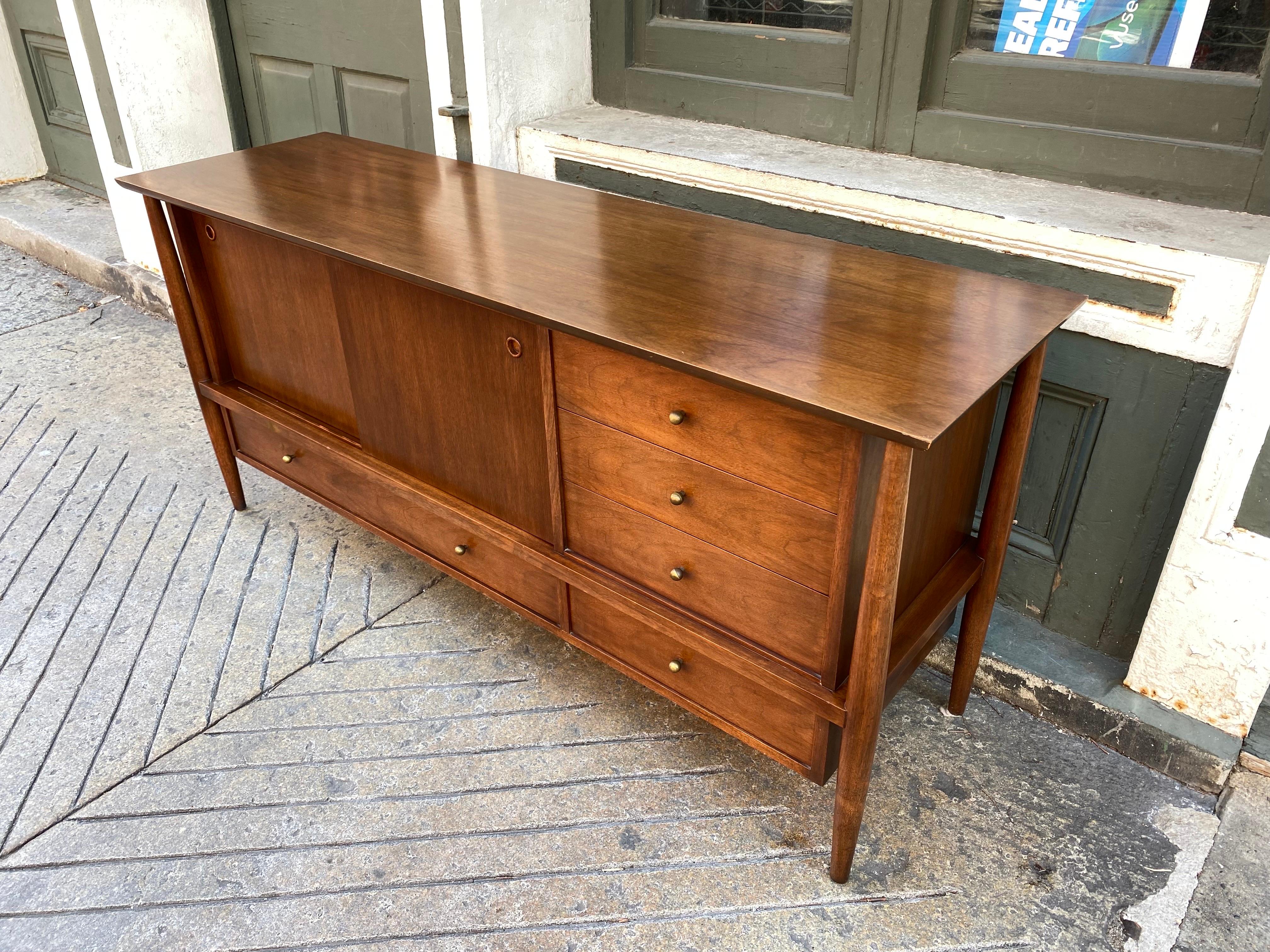 Walnut Buffet or Credenza sold through John Stuart. Made by the company Mt. Airy. Nice design with a Finn Juhl Influence with floating body and attached legs. In Original condition with one minor touch up to back left corner as seen in photo.