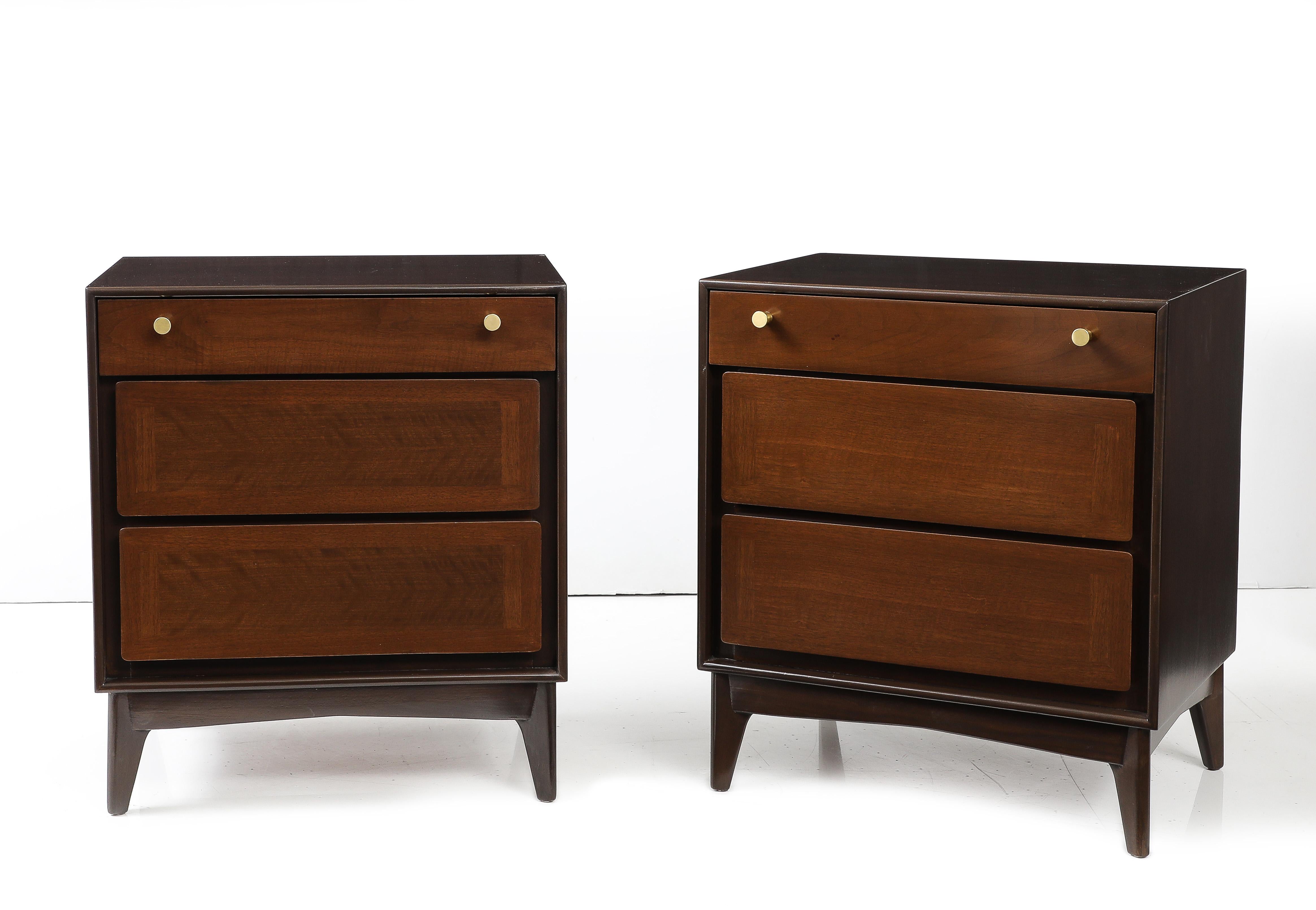 John Stuart Mid-Century nightstands featuring solid dark brown stained Walnut case and 3 lighter stained drawers. Each drawer having si=olid brass conical pulls. Mint restored. 