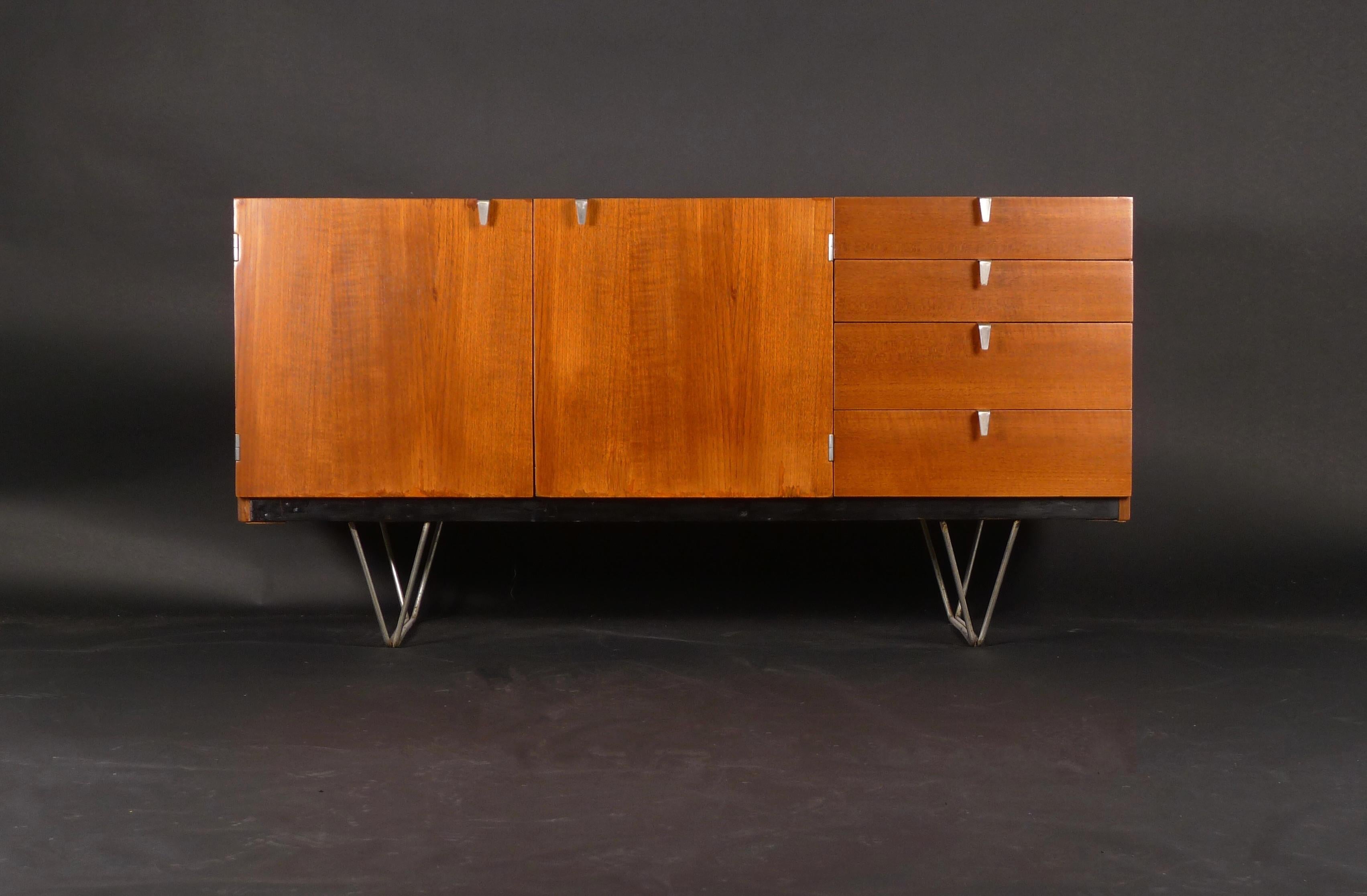 Model S201 Teak Sideboard, designed by John & Sylvia Reid as part of the S range brought out by Stag Furniture.

Two-door cupboard containing adjustable shelves and a bank of four graduated drawers to the right, with V shaped metal pulls.  Stag