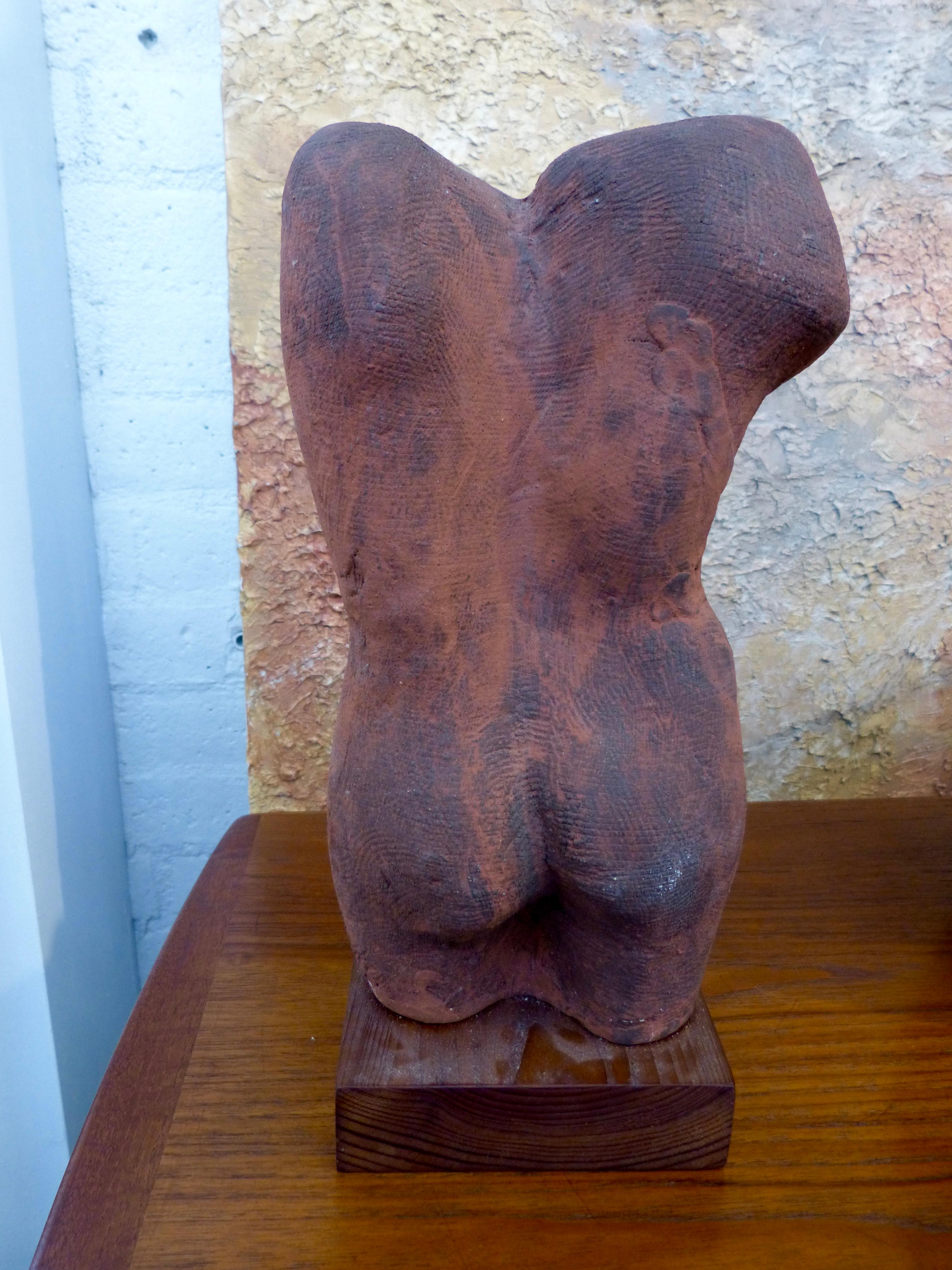 A pottery nude torso out of John Tuska's estate. This pottery torso is unsigned. Minor glaze flakes and imperfections. Some fading to the wood base.