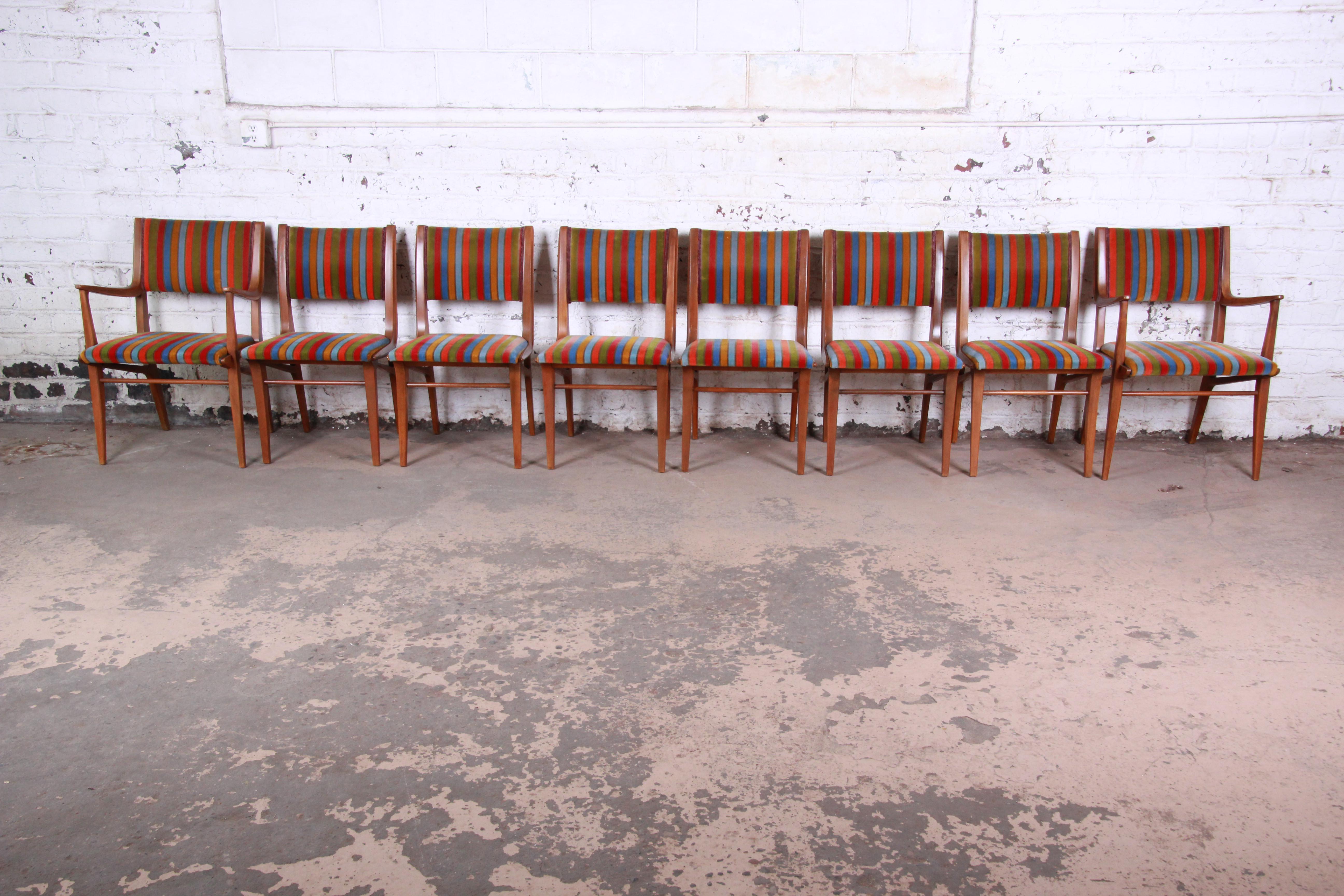 An exceptional set of eight Mid-Century Modern dining chairs designed by John Van Koert for his profile line for Drexel furniture. The set includes two captain armchairs and six side chairs. The chairs feature gorgeous solid sculpted walnut frames