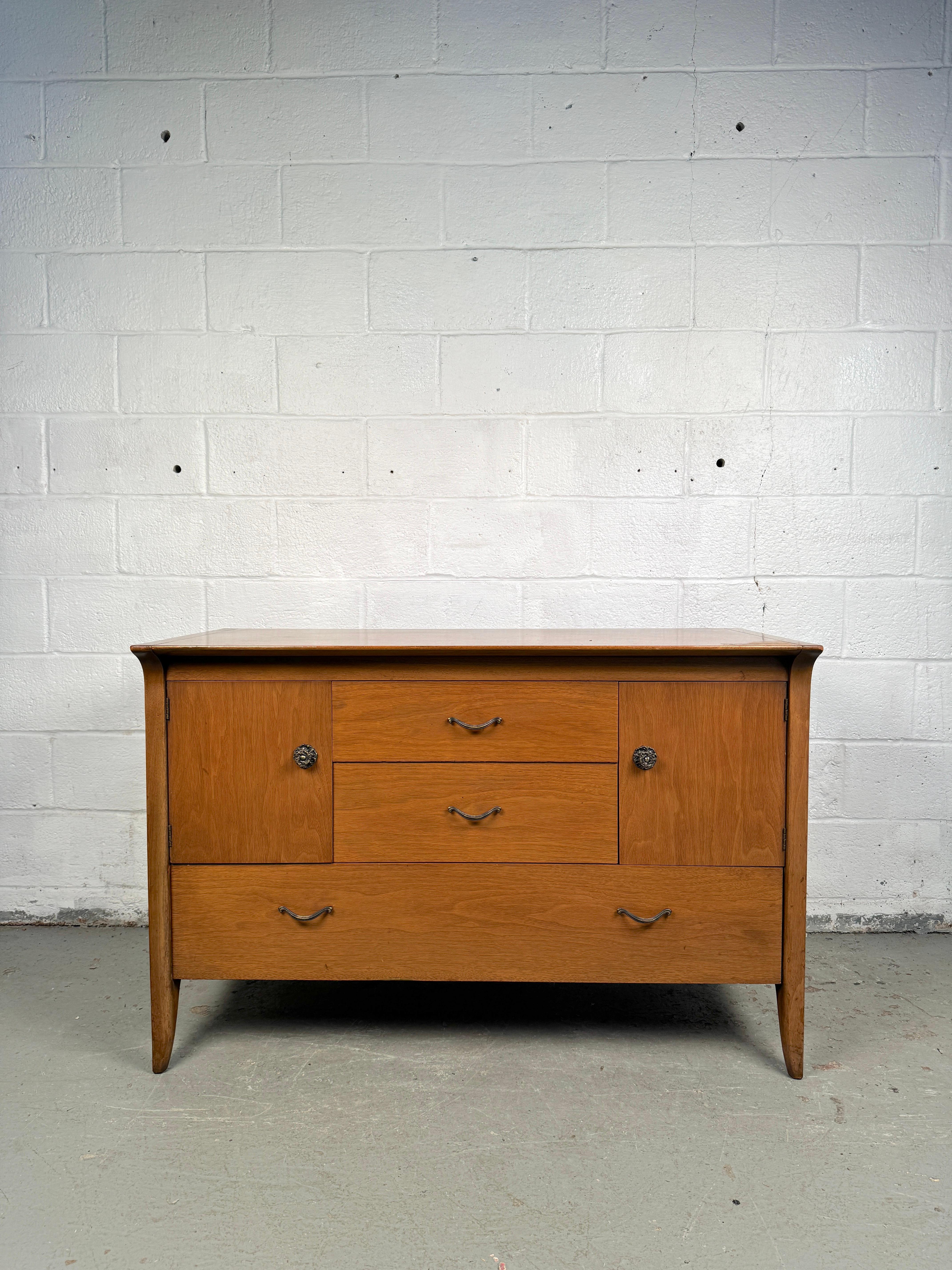 Designed by John Van Koert for Drexel, this exquisite mid-century modern sideboard buffet is a masterclass in understated elegance and fine craftsmanship. Part of the celebrated “Profile” collection introduced in the 1950s, this piece embodies the
