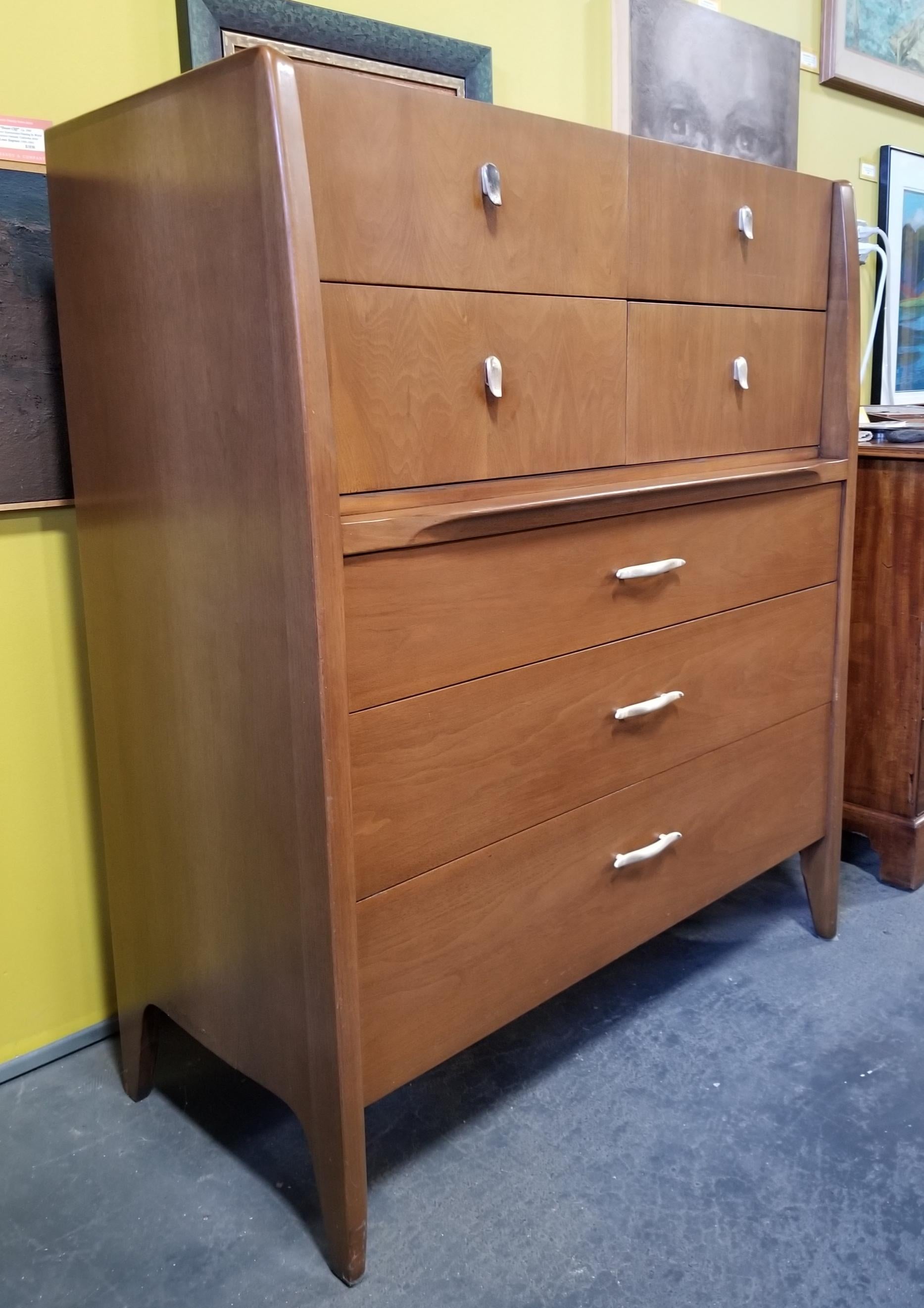 Quality craftsmanship and materials in this Mid-Century Modern highboy dresser designed by John Van Koert for Drexel Furniture. All wood construction solid oak secondary woods and dovetail detail. Drop-down drawer reveals flip up mirror. Very good