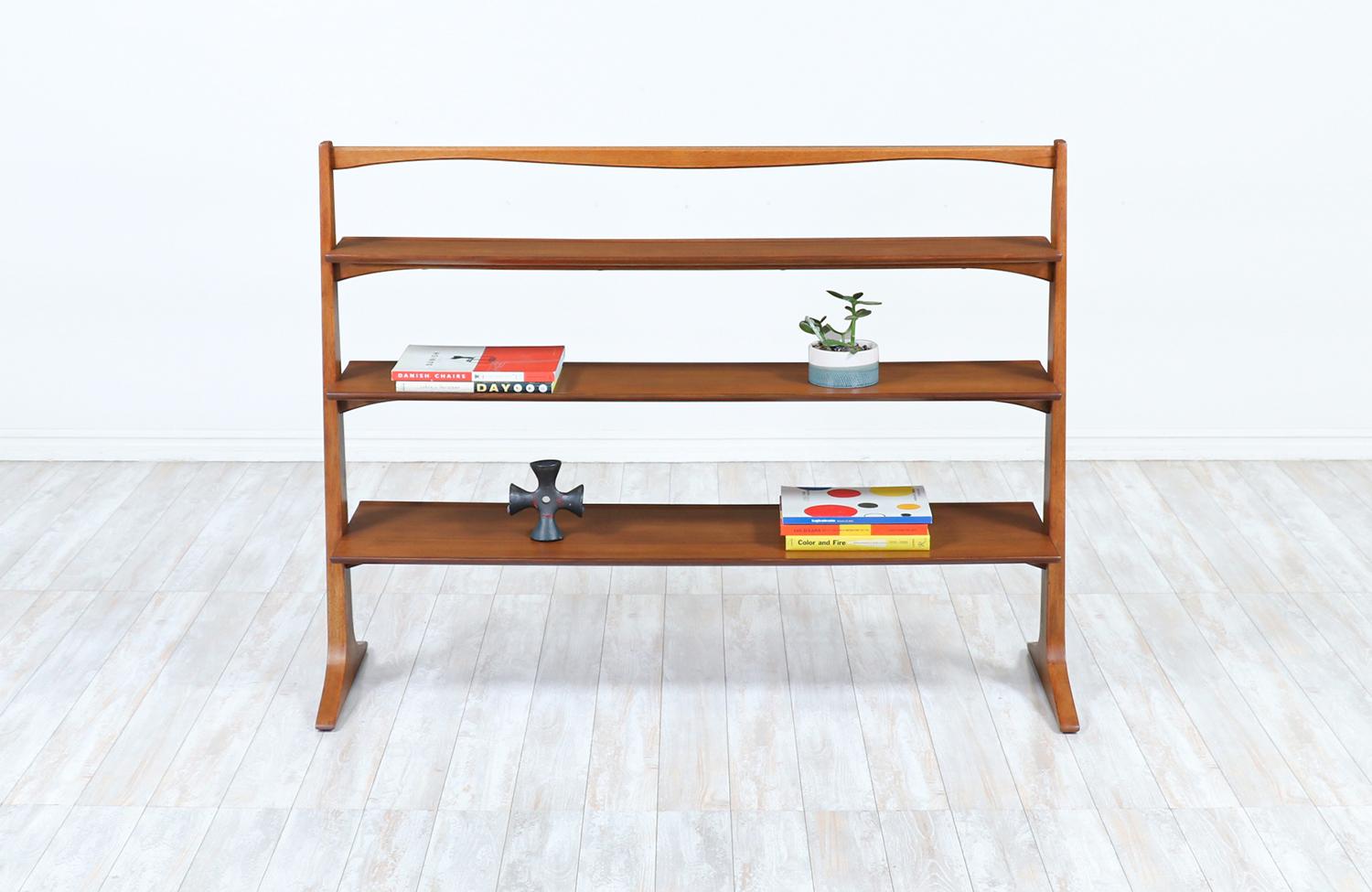 Mid-Century Modern bookshelf designed by American designer John Van Koert and manufactured by Drexel in the United States, circa 1950s. With a solid and stable walnut wood frame and three tapered shelves, this bookshelf illustrates a stylish and