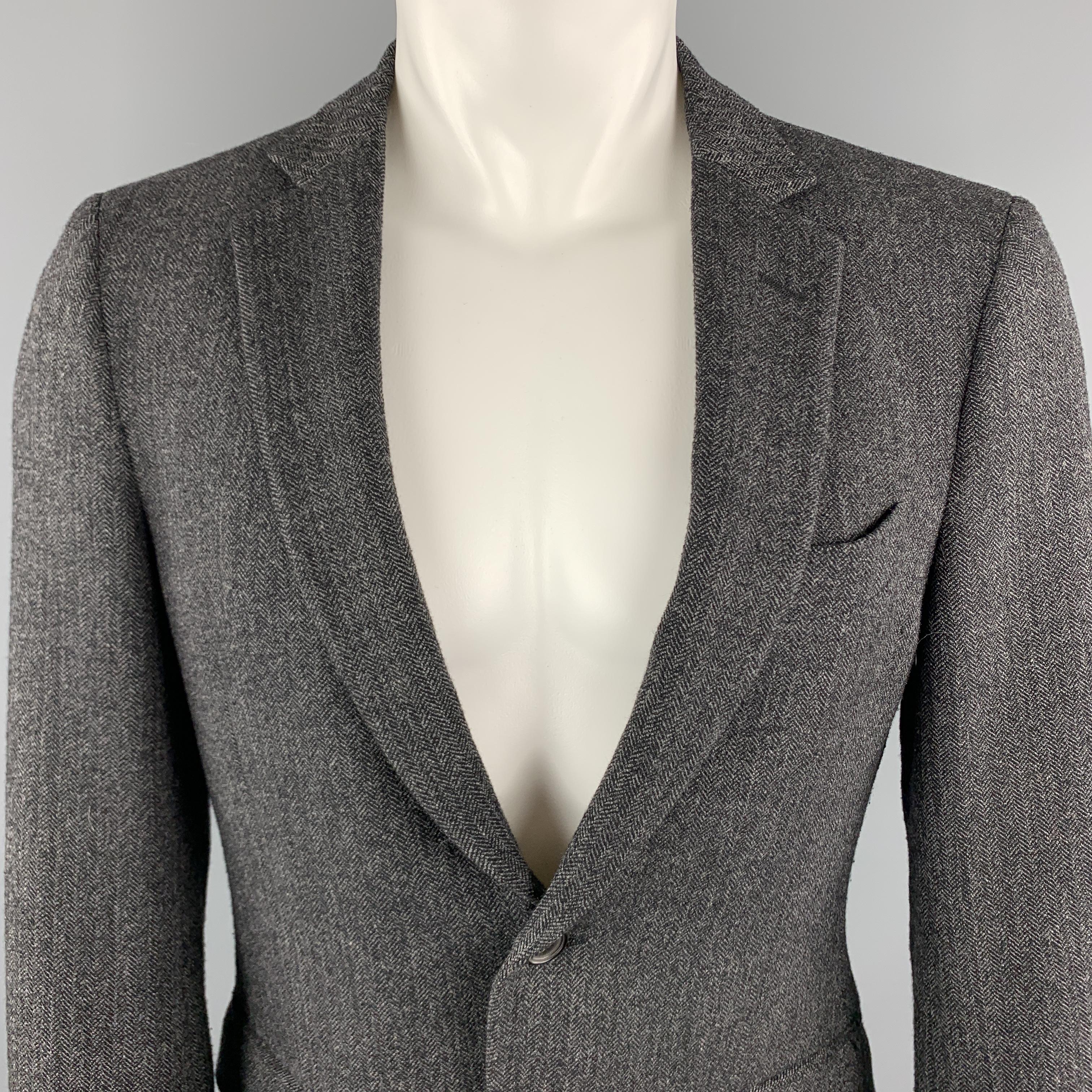 JOHN VARVATOS Sport Coat comes in a charcoal and black herringbone wool material, featuring a notch lapel, two buttons at closure, slit and flap pockets, single breasted, buttoned cuffs, and a double vent at back. Made in Italy. 

Excellent