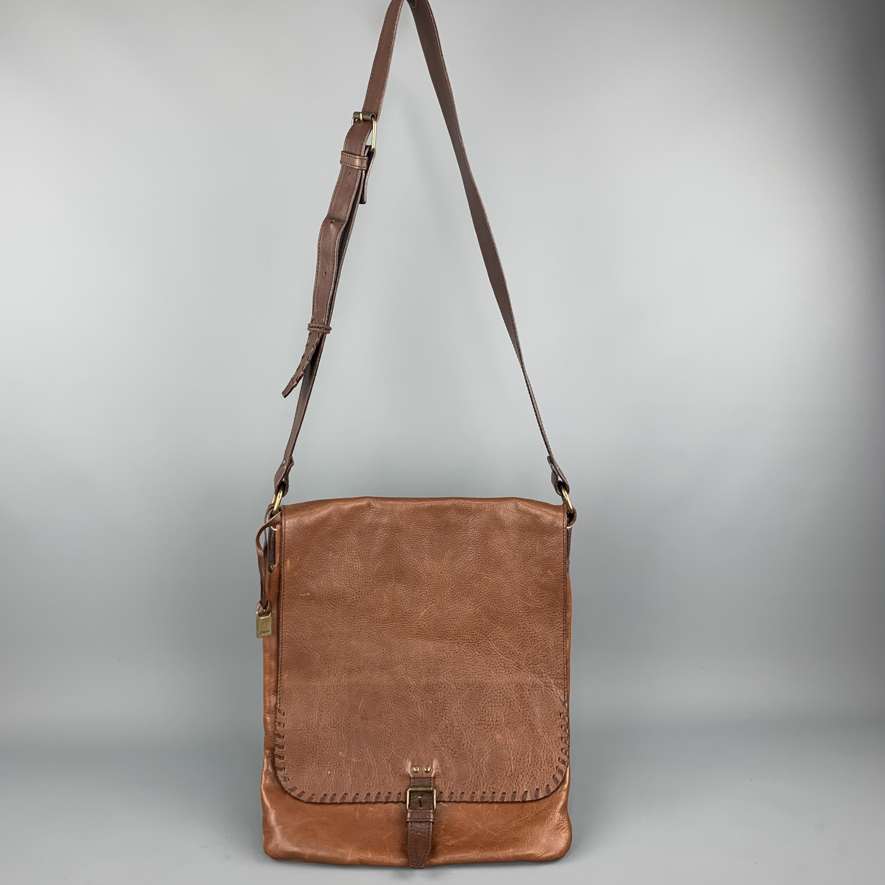 JOHN VARVATOS messenger bag comes in tan pebbled leather with a frontal flap, mock buckle snap closure, whipstitch trim, and crossbody strap. Wear throughout. Stain on back. As-is. Hand Made in Italy. 

Good Pre-Owned Condition.
Original Retail