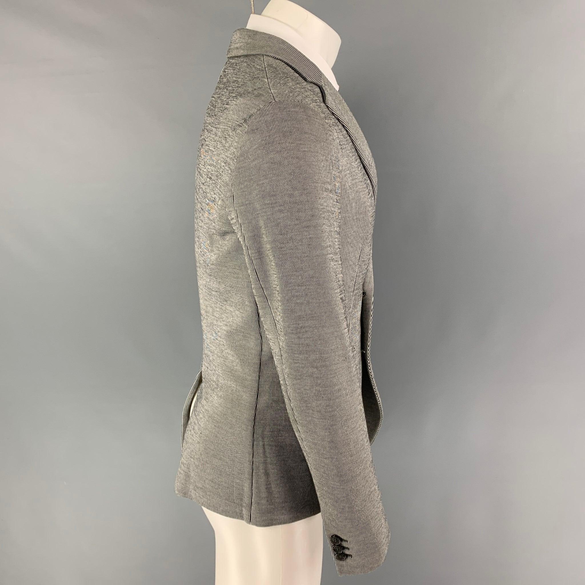 JOHN VARVATOS sport coat comes in a black & beige pinstripe cotton featuring a notch lapel, slit pockets, single back vent, and a double breasted closure. Made in Italy.
Very Good
Pre-Owned Condition. 

Marked:   46 

Measurements: 
 
Shoulder: 17.5