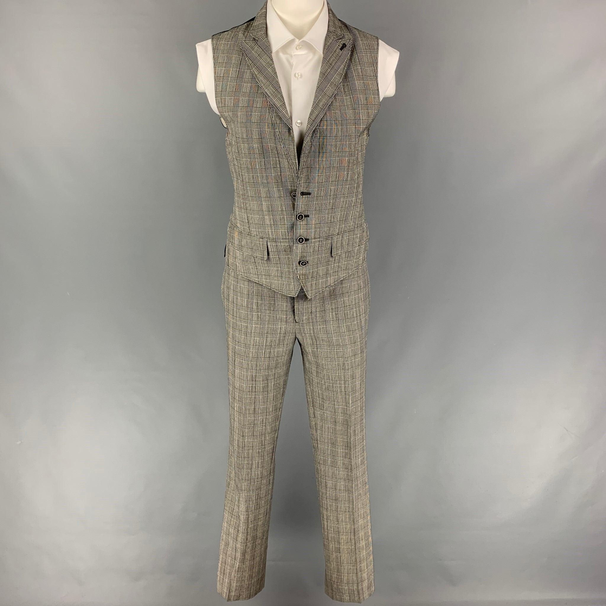 JOHN VARVATOS
Le costume est en laine glenplaid noire et blanche et comprend un gilet boutonné à simple boutonnage avec un revers en pointe et un pantalon assorti à devant plat. Fabriquées en Italie. Très bon état d'origine. 

Marqué :   46