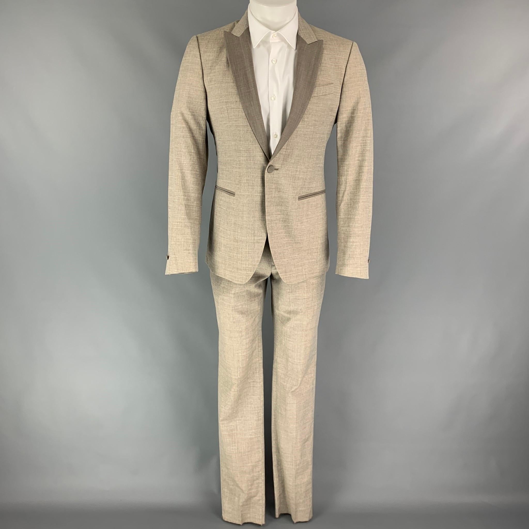 JOHN VARVATOS suit comes in a oatmeal heather wool with a full liner and includes a single breasted, single button sport coat with peak lapel and matching flat front trousers. Made in Italy.

New With Tags.
Marked: