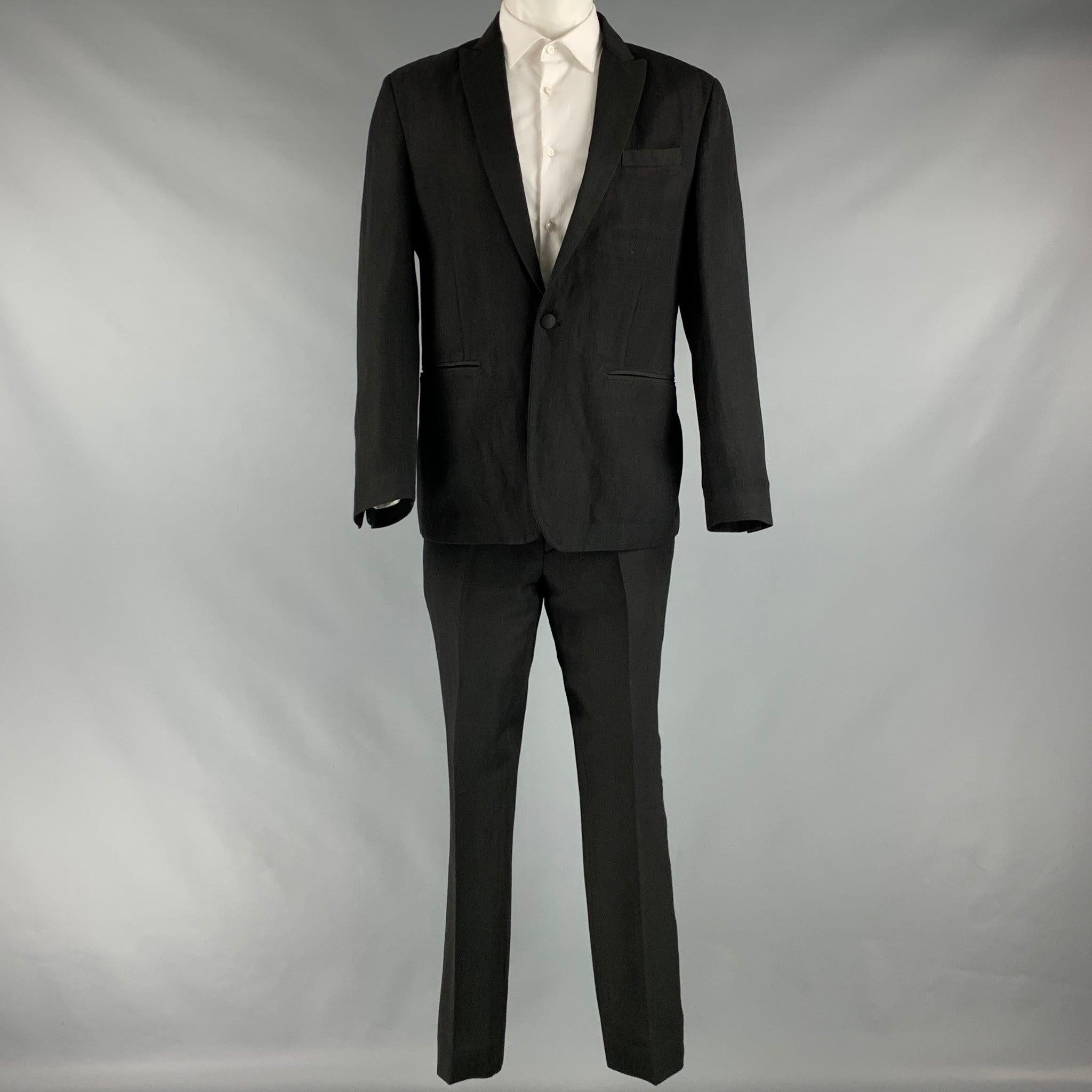 JOHN VARVATOS suit comes in a black linen and wool woven material featuring a peak lapel, welt pockets, single back vent, and a single button closure. Matching pants with a flat front pants. Made in Italy.Excellent Pre-Owned Condition. 

Marked:  