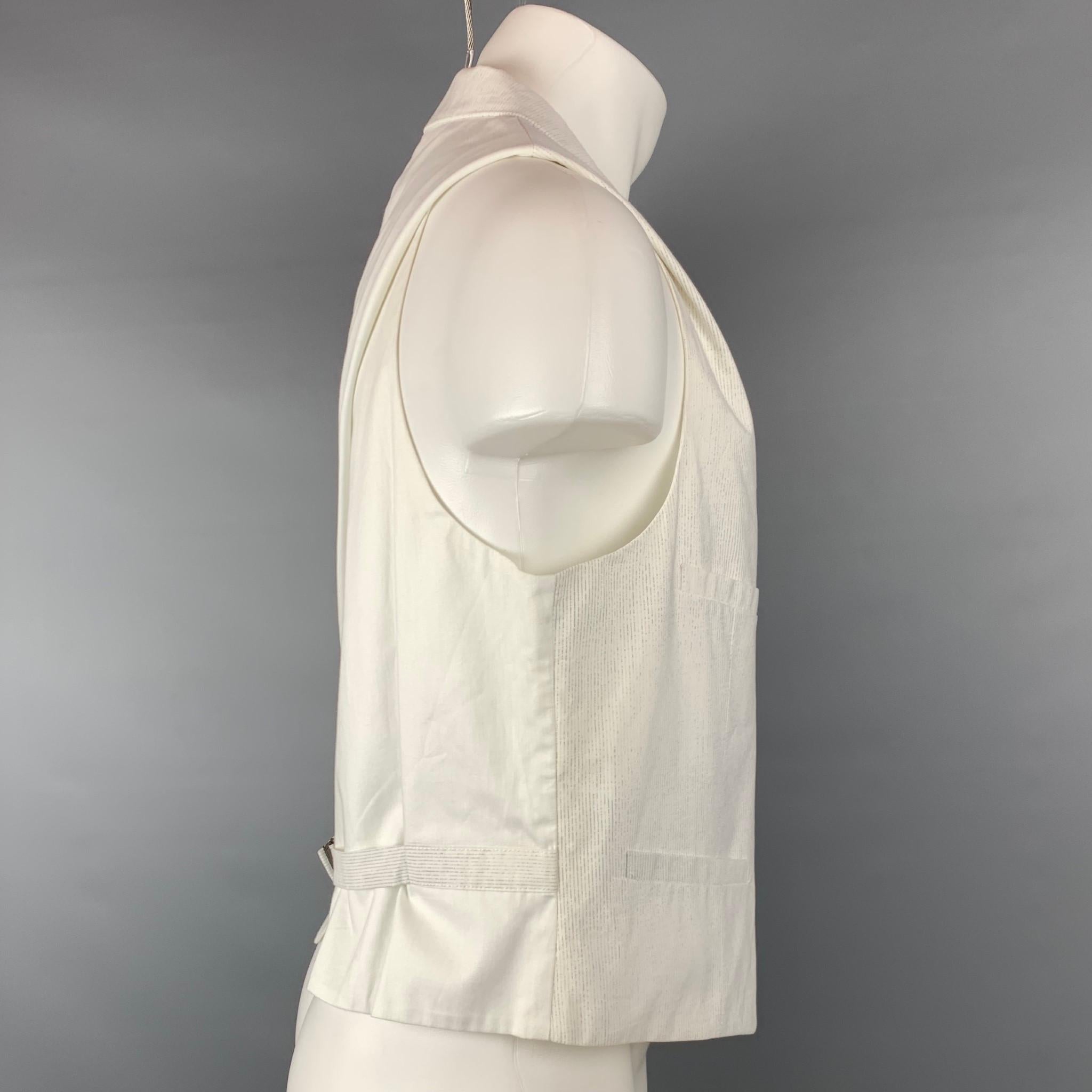 JOHN VARVATOS vest comes in a white & grey pinstripe cotton with a full liner featuring a peak lapel, solid back, slit pockets, back belt, and a buttoned closure. Made in Italy.

Very Good Pre-Owned Condition.
Marked: IT 54

Measurements:

Shoulder: