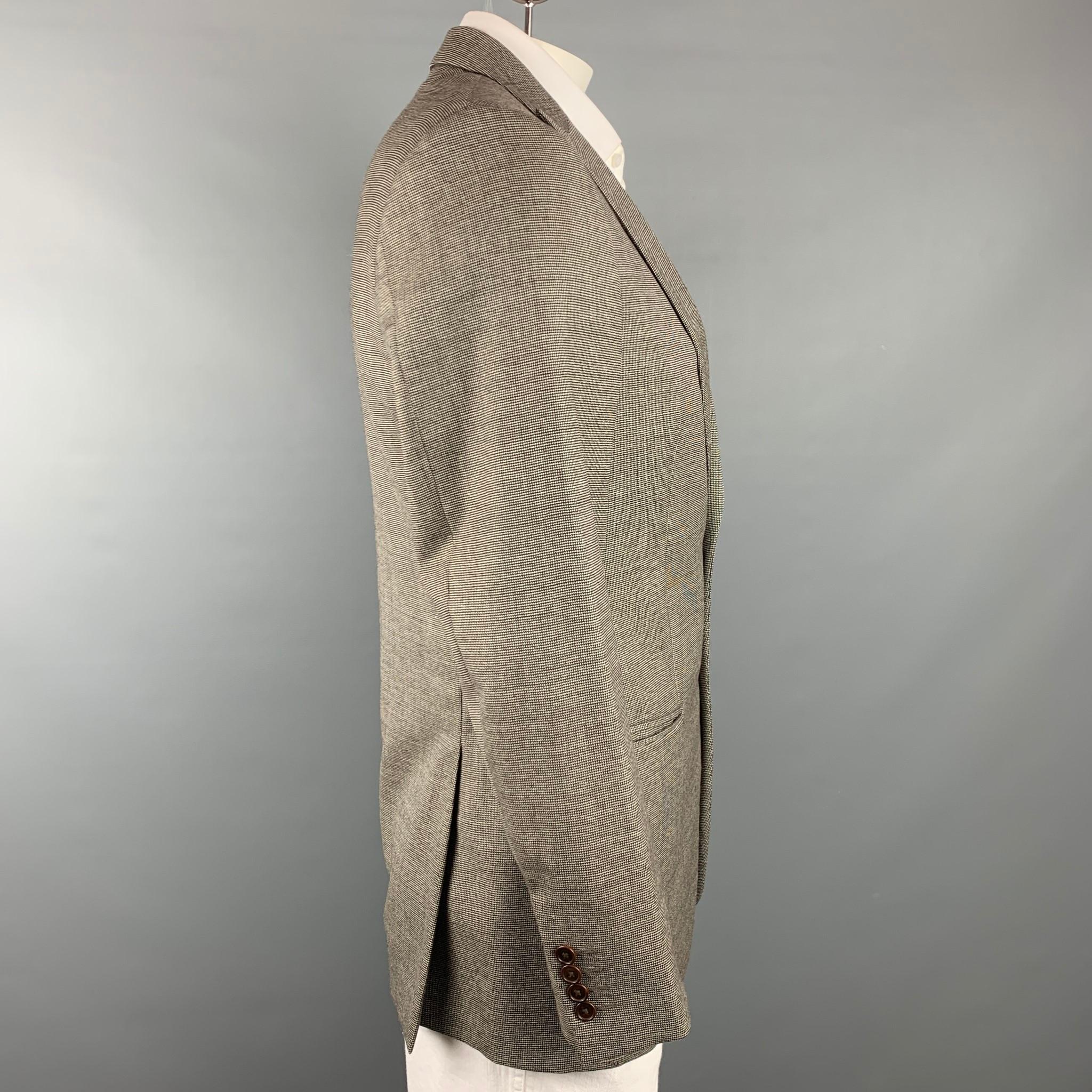 JOHN VARVATOS sport coat comes in a brown & white houndstooth virgin wool with a full liner featuring a peak lapel, slit pockets, and a two button closure.

Very Good Pre-Owned Condition.
Marked: 48

Measurements:

Shoulder: 18 in.
Chest: 41