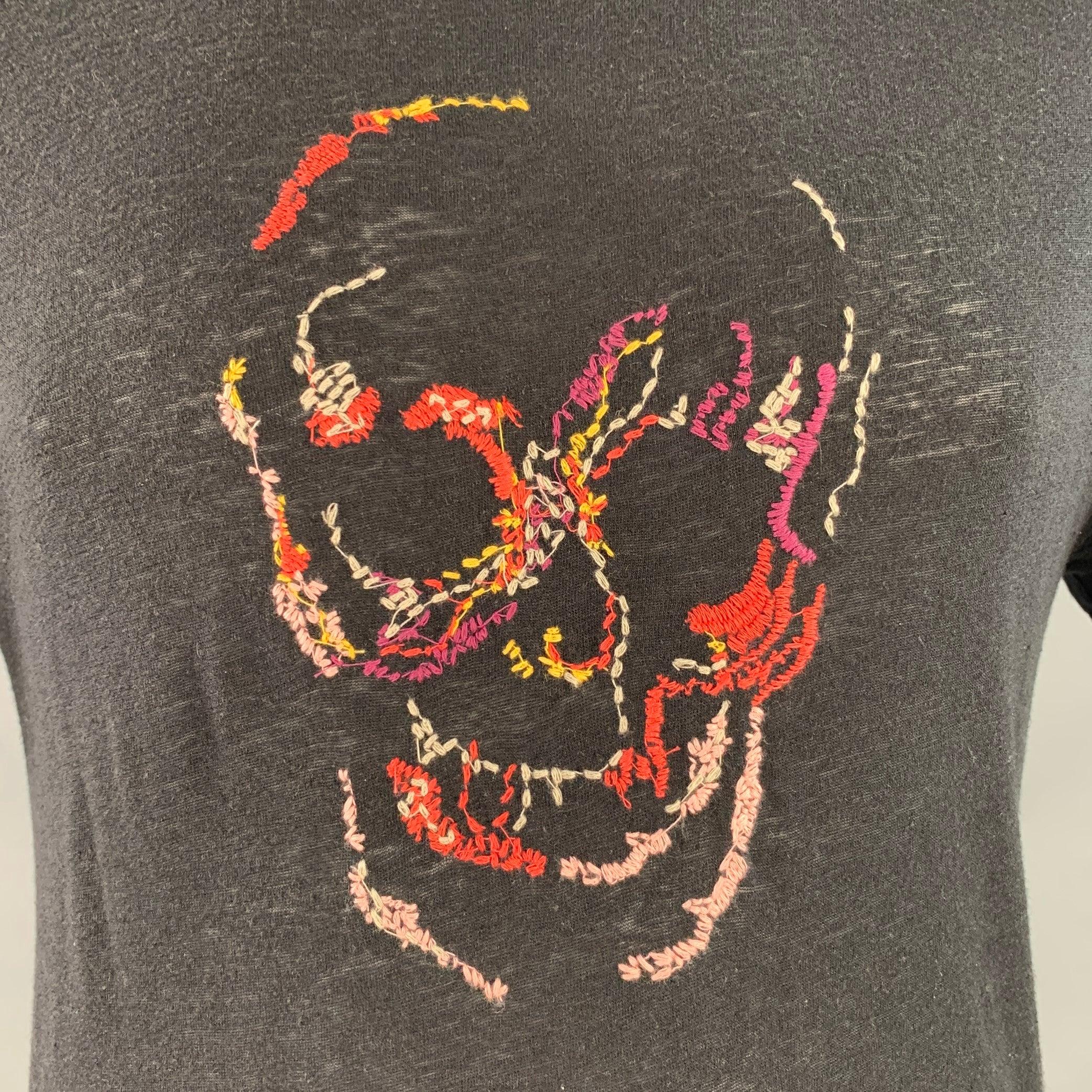 JOHN VARVATOS * U.S.A. T-Shirt aus schwarzem Baumwoll-Jersey mit mehrfarbig gesticktem Totenkopf und Rundhalsausschnitt. Mäßige Pillingbildung, Etiketten entfernt. 

Markiert:   L 

Abmessungen: 
 
Schultern: 18 Zoll Brust: 42 Zoll Ärmel: 8 Zoll