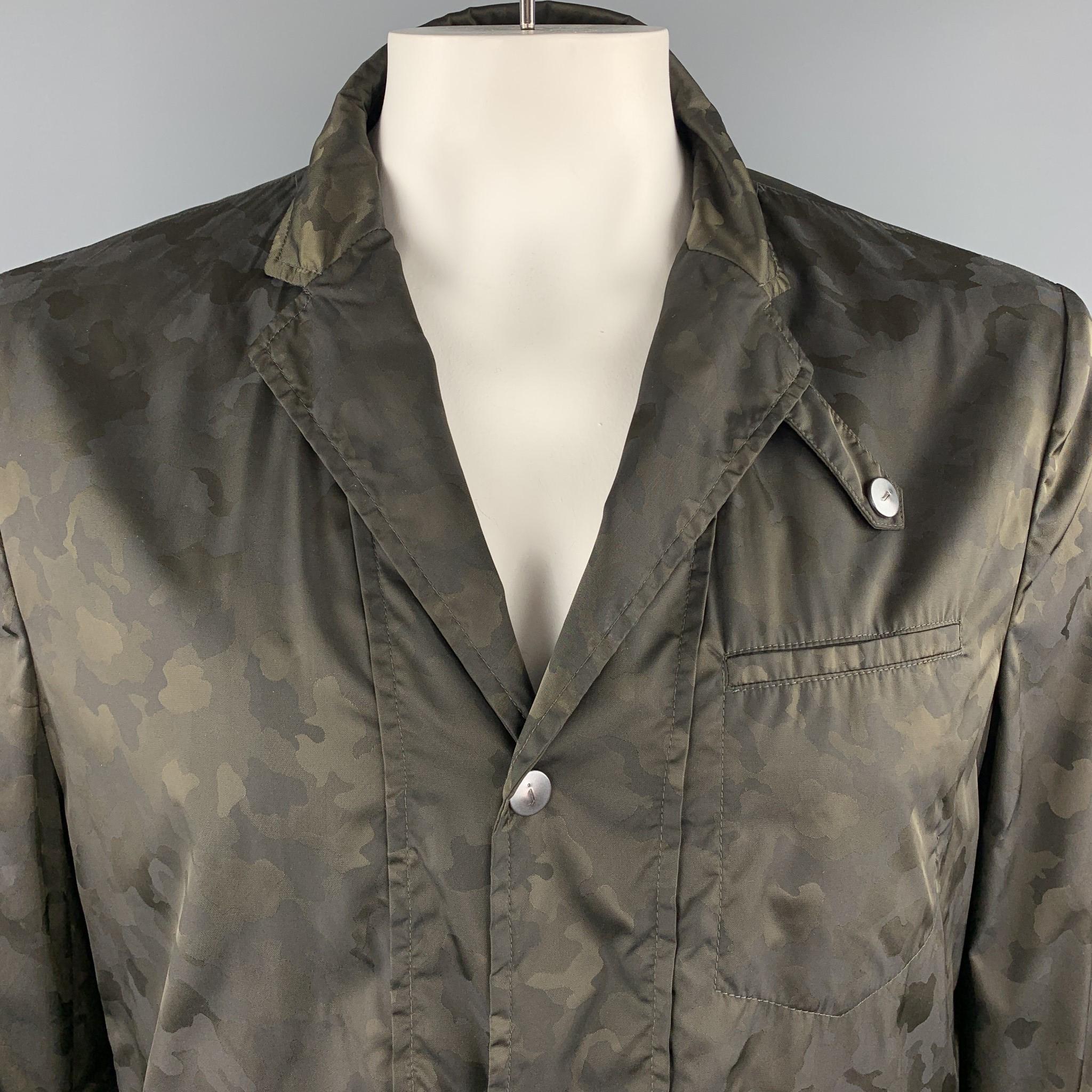 JOHN VARVATOS sport coat comes in olive green camouflage windbreaker fabric with a notch lapel, single breasted,  snap closure front, and zip and flap pockets. Made in Italy.

Excellent Pre-Owned Condition.
Marked: IT 52

Measurements:

Shoulder: 18