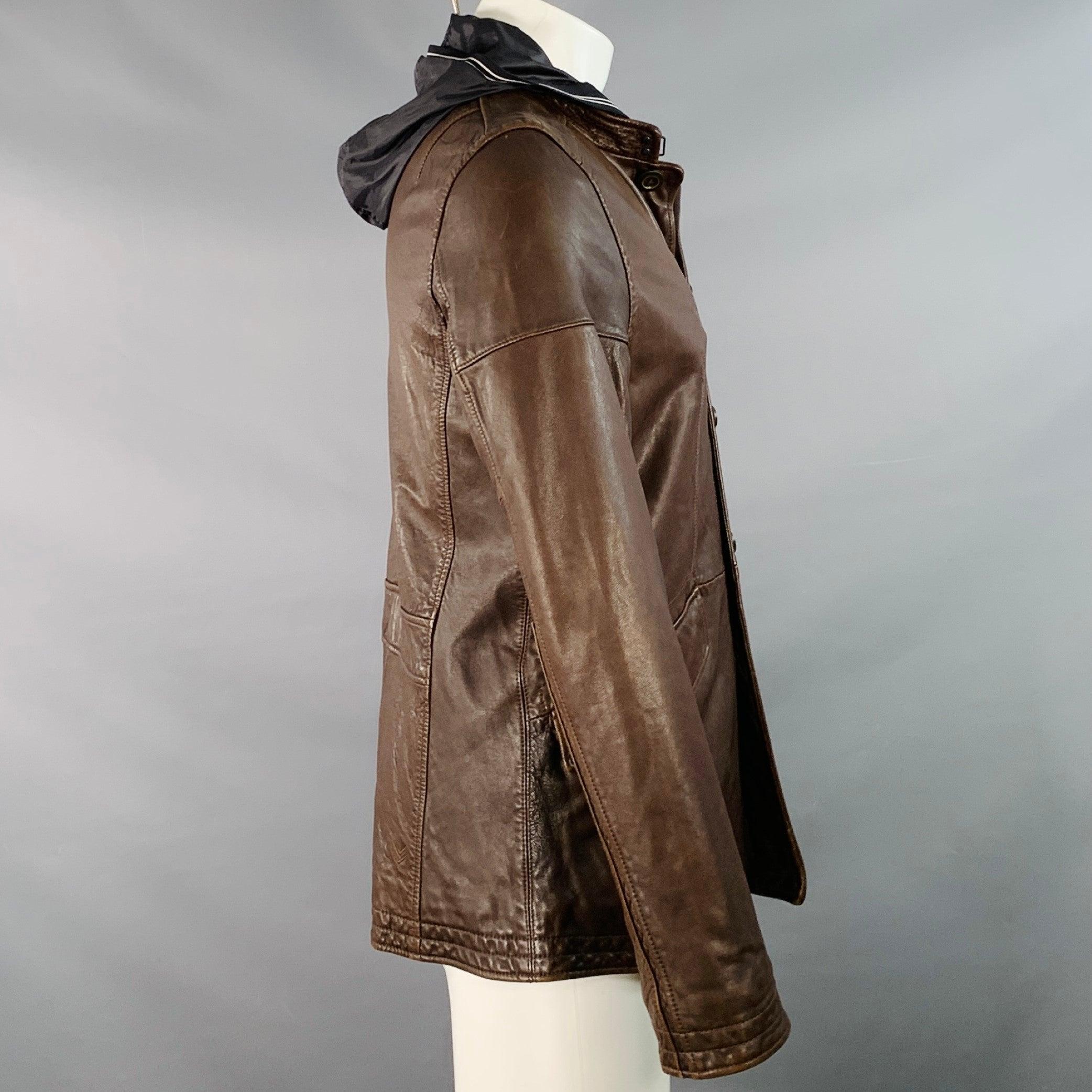 Chaqueta CONVERSE by JOHN VARVATOS
de cuero marrón, con capucha de nylon negro en contraste, dos bolsillos exteriores con botón y cierre de botones.Muy buen estado de segunda mano. Pequeños signos de desgaste. 

Marcado:   2/M 

Medidas: 
 
Hombro