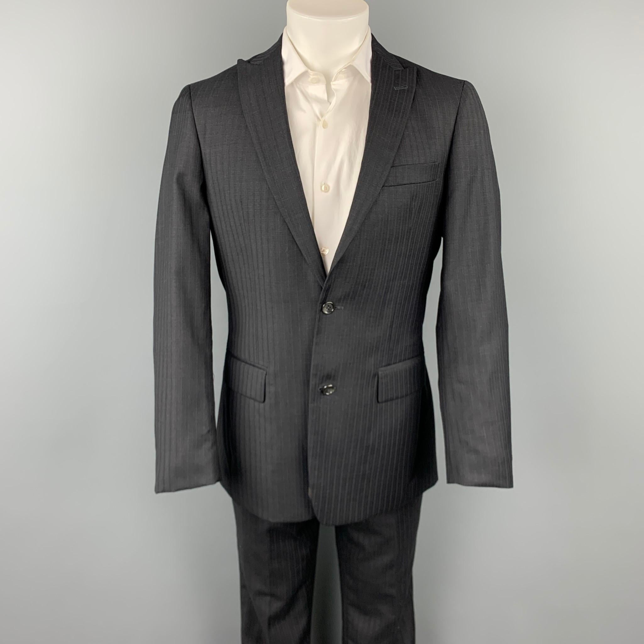 JOHN VARVATOS *U.S.A suit comes in a black wool with a full liner and includes a single breasted, two button sport coat with a notch lapel and matching flat front trousers. 

Very Good Pre-Owned Condition.
Marked: