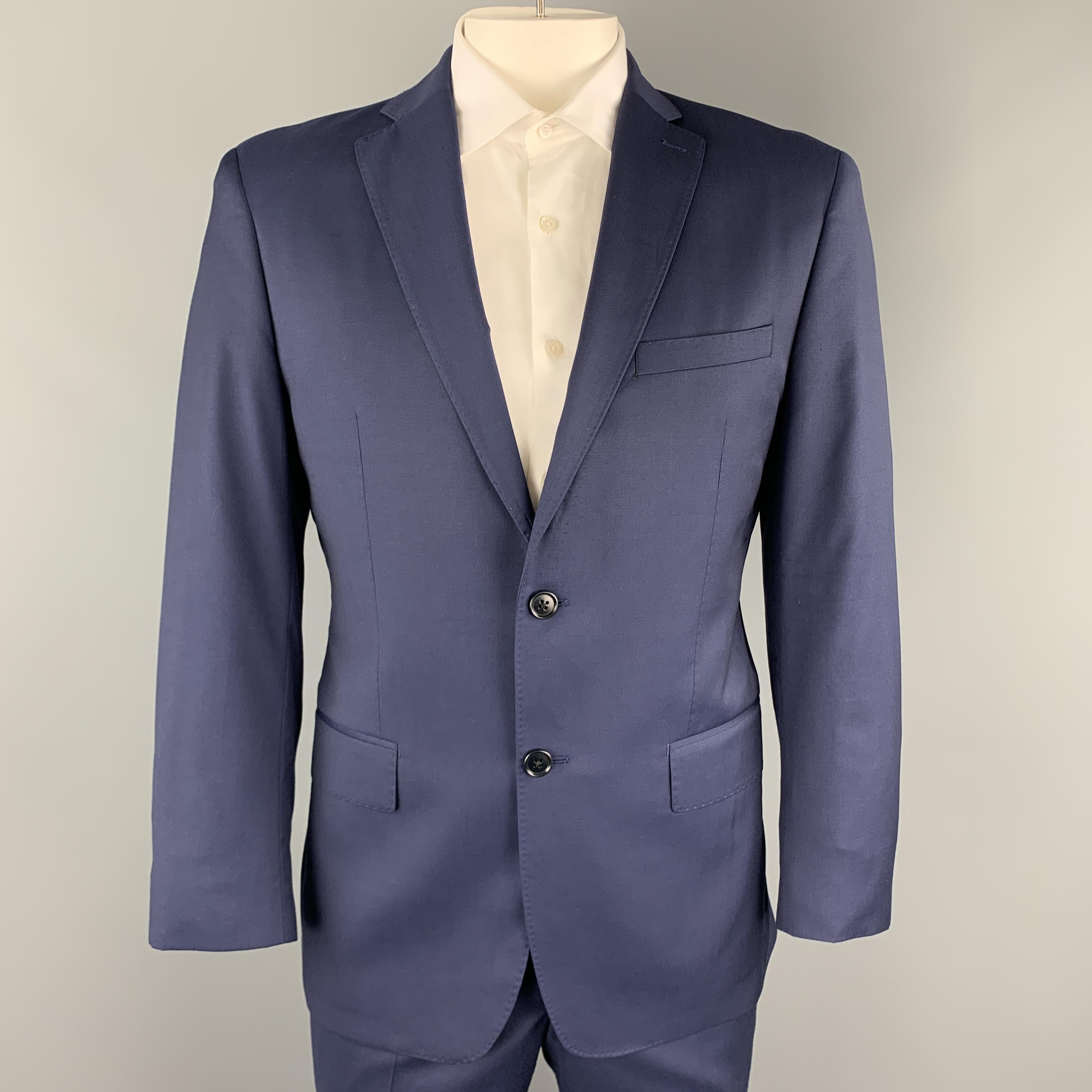 JOHN VARVATOS USA suit comes in navy blue wool and includes a single breasted, two button sport coat with a top stitch notch lapel and matching flat front trousers. Made in Canada.

Excellent Pre-Owned Condition.
Marked: USA 42