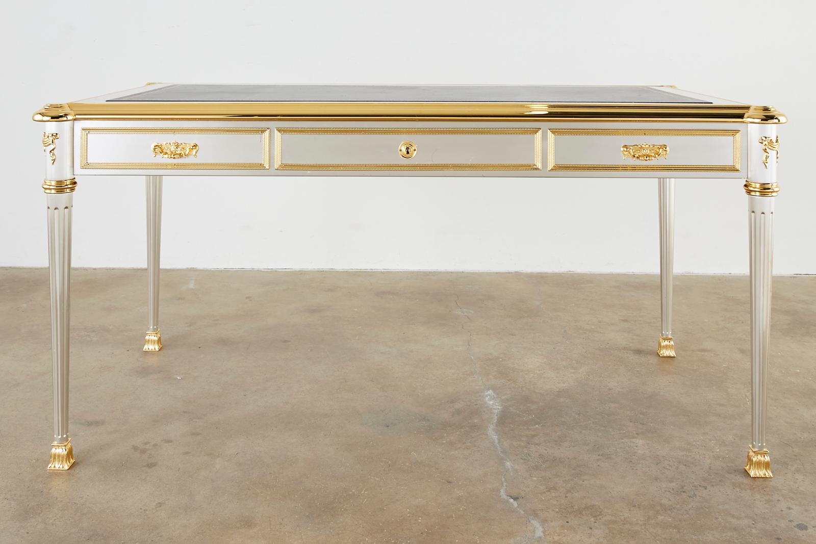 Extraordinary mid-century modern stainless steel and bronze writing table, desk, or bureau plat designed by John Vesey (American 1924-1992). Made in the grand neoclassical French Louis XVI taste featuring polished gilt bronze trim and an iconic