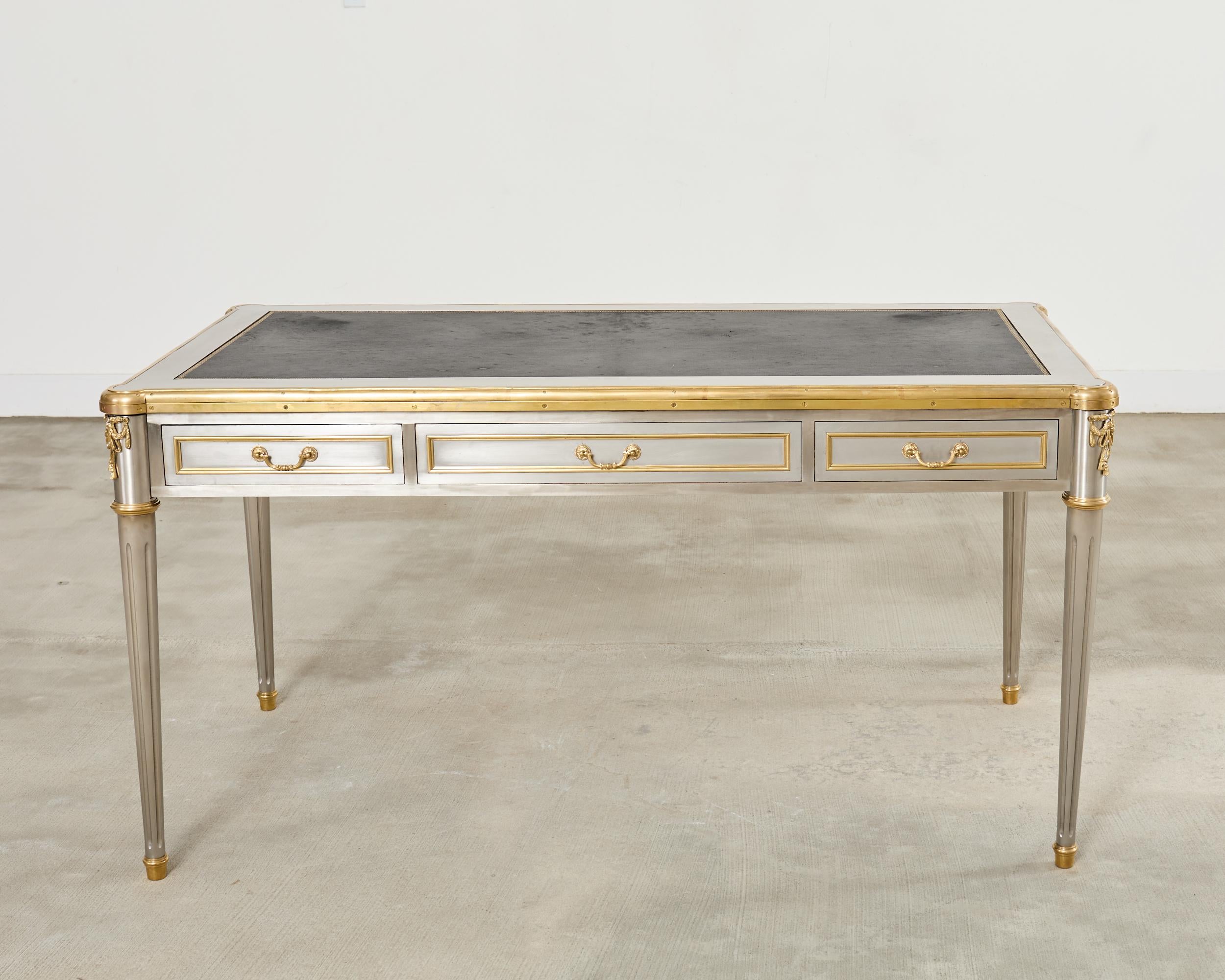 Glamorous and opulent 1960s stainless steel clad writing table, library table, or bureau plat desk designed by John Vesey (American 1924-1992). Made in the grand neoclassical French Louis XVI taste reminiscent of works by Maison Jansen. The case