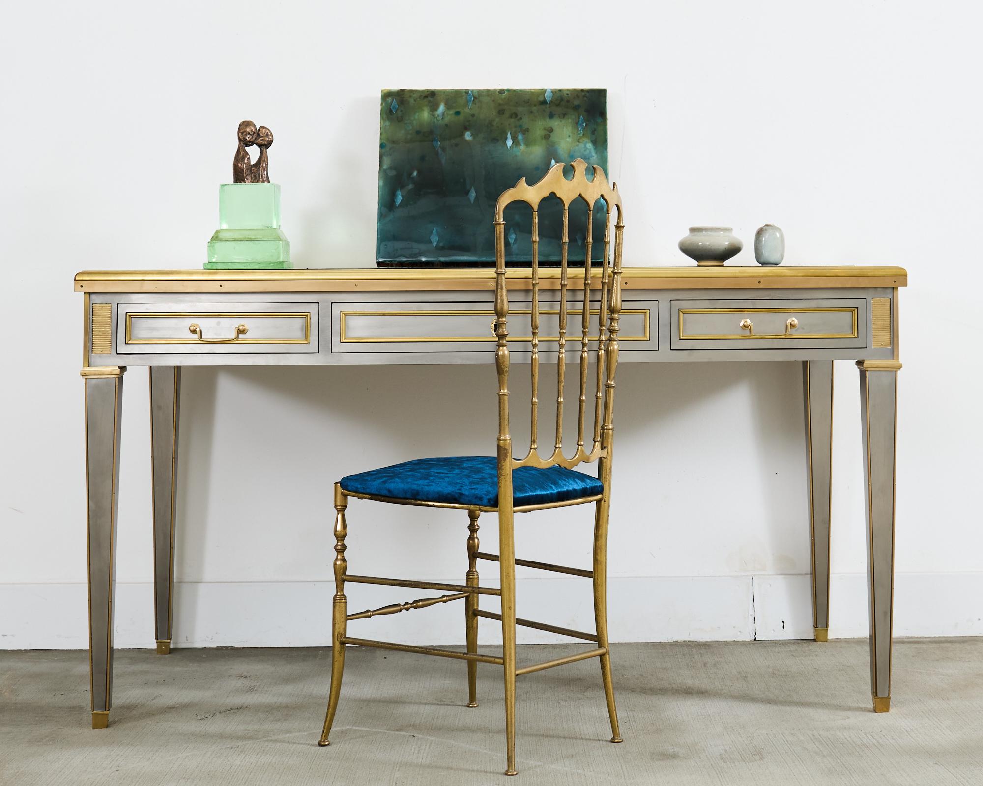 Imposing and iconic 20th century stainless steel and bronze mounted library writing table or desk made in the manner and style of John Vesey  (American 1924-1992). The desk is constructed from an oak frame embellished with stainless steel veneered
