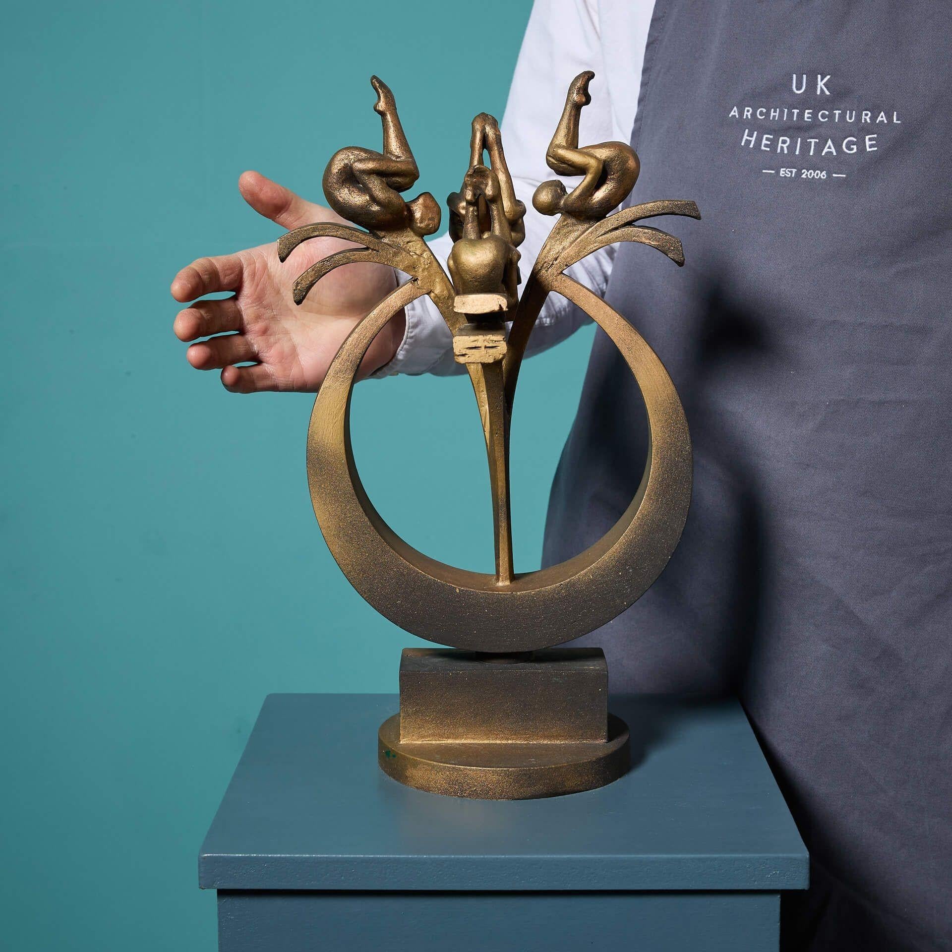 Escultura de sobremesa extremadamente decorativa, pintada en oro y patinada en bronce, que representa a cuatro buceadores sincronizados, titulada 