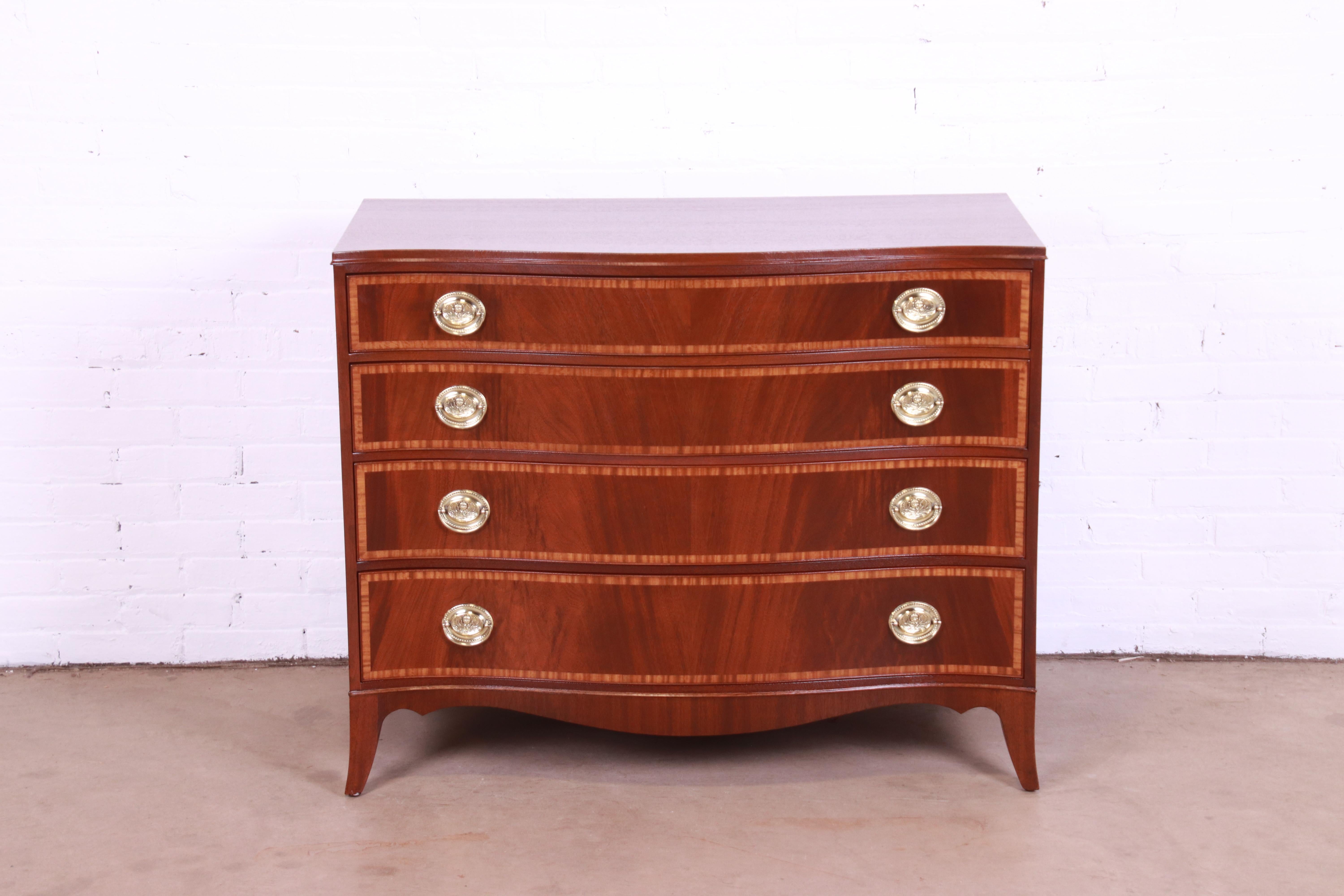 A gorgeous Georgian style serpentine front four-drawer chest of drawers or commode

By John Wanamaker

USA, 1947

Flame mahogany, with satinwood banding and original brass hardware.

Measures: 42.75