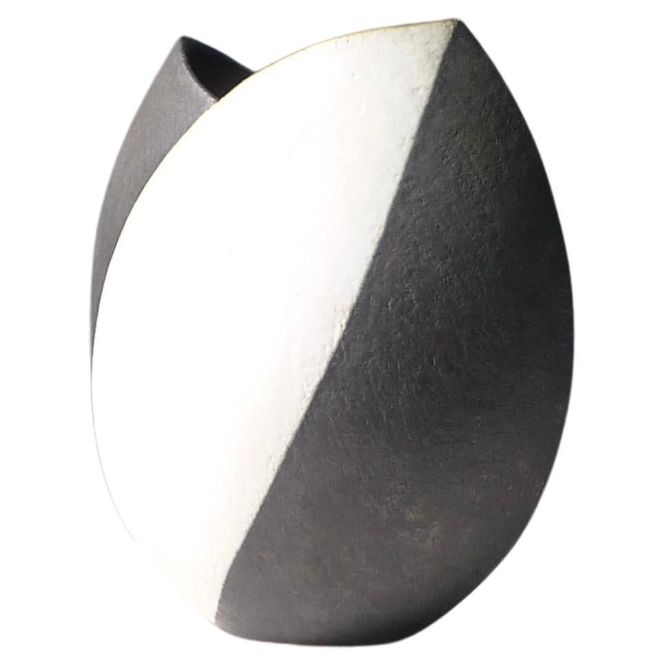 John Ward (1938-2023)
Tulip Pot, circa 1990
stoneware, of flattened elliptical form with asymmetric cut rim, matt black and white alternating bands
impressed JW seal to base
29cm high, 27cm wide, 15cm deep

Condition excellent