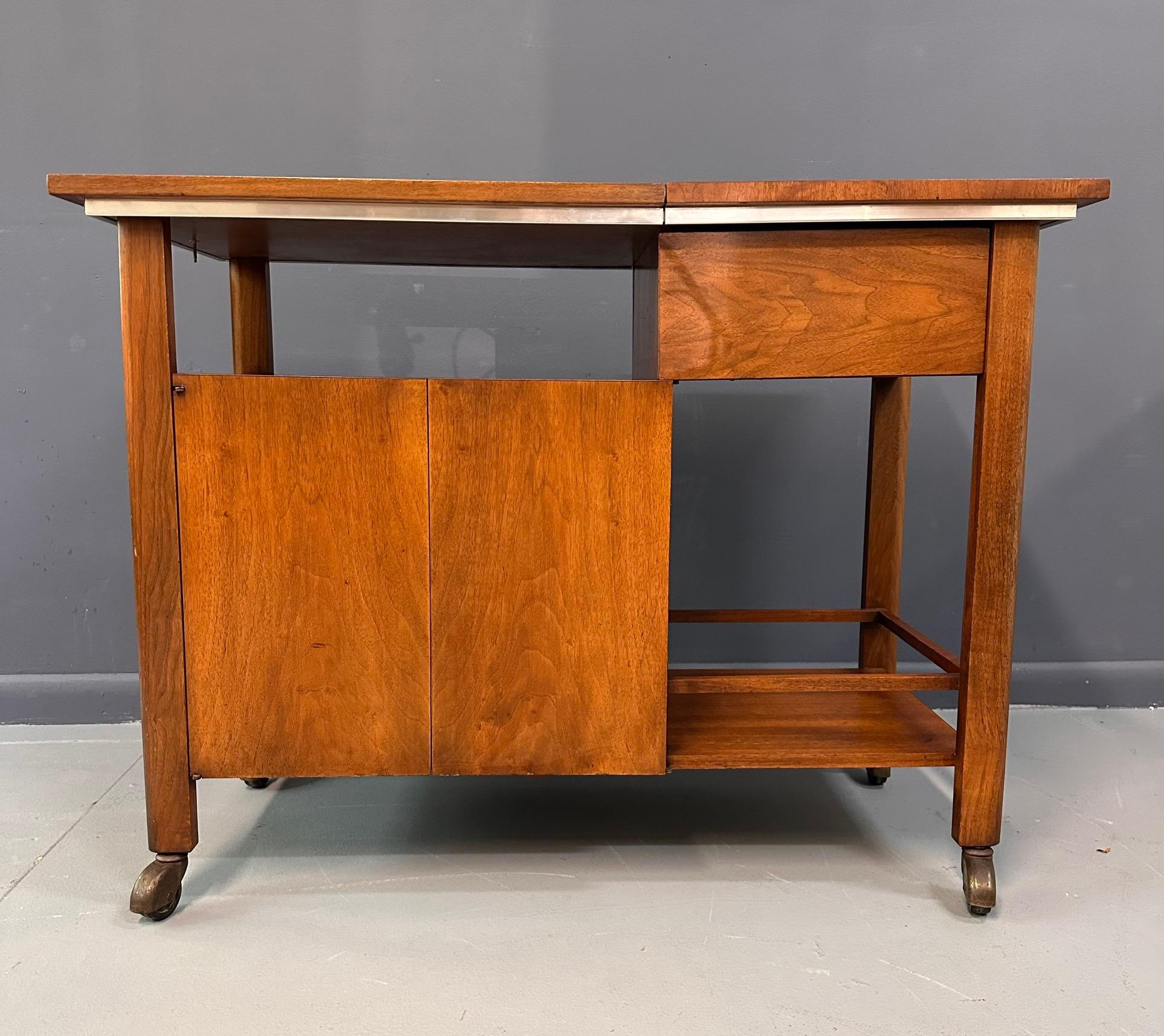 This striking John Widdicomb bar cart or serving cart has several great features: a terrific graphic quality with a dynamic composition of clear and opaque shapes, a top that expands for additional work surface (including hard-wearing and water