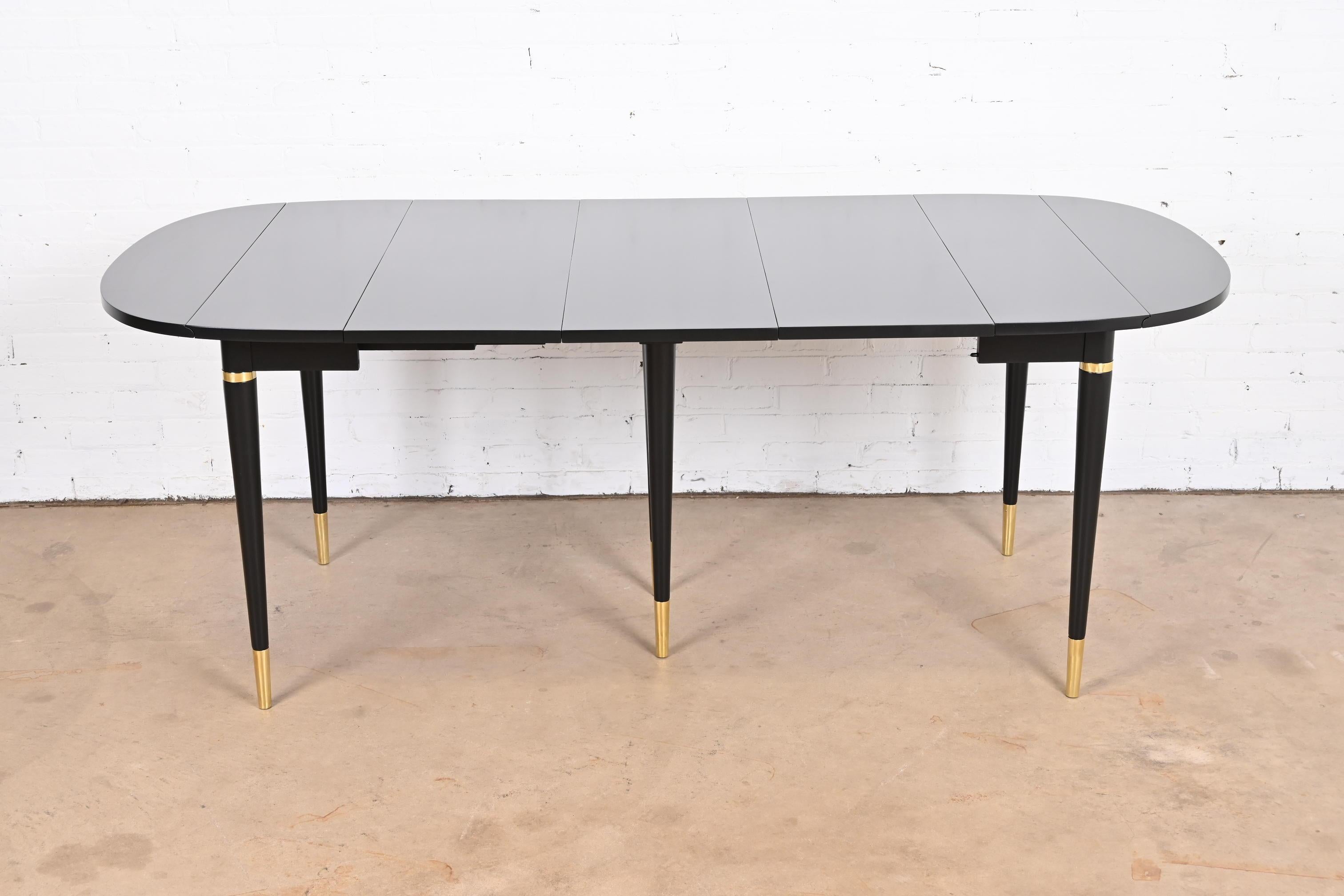 An exceptional Mid-Century Modern extension dining table

By John Widdicomb

USA, 1950s

Black lacquered cherry wood, with brass accents and brass sabots.

Measures:
Fully extended - 78