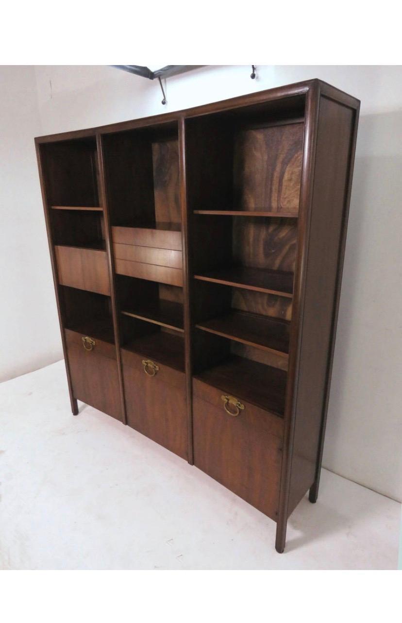 Stunning walnut bow front freestanding wall unit designed by Bert England for John Widdicomb, circa 1950.
Features solid brass hardware, upper cabinets and shelves that are height adjustable within their three bays and a finished walnut panel back