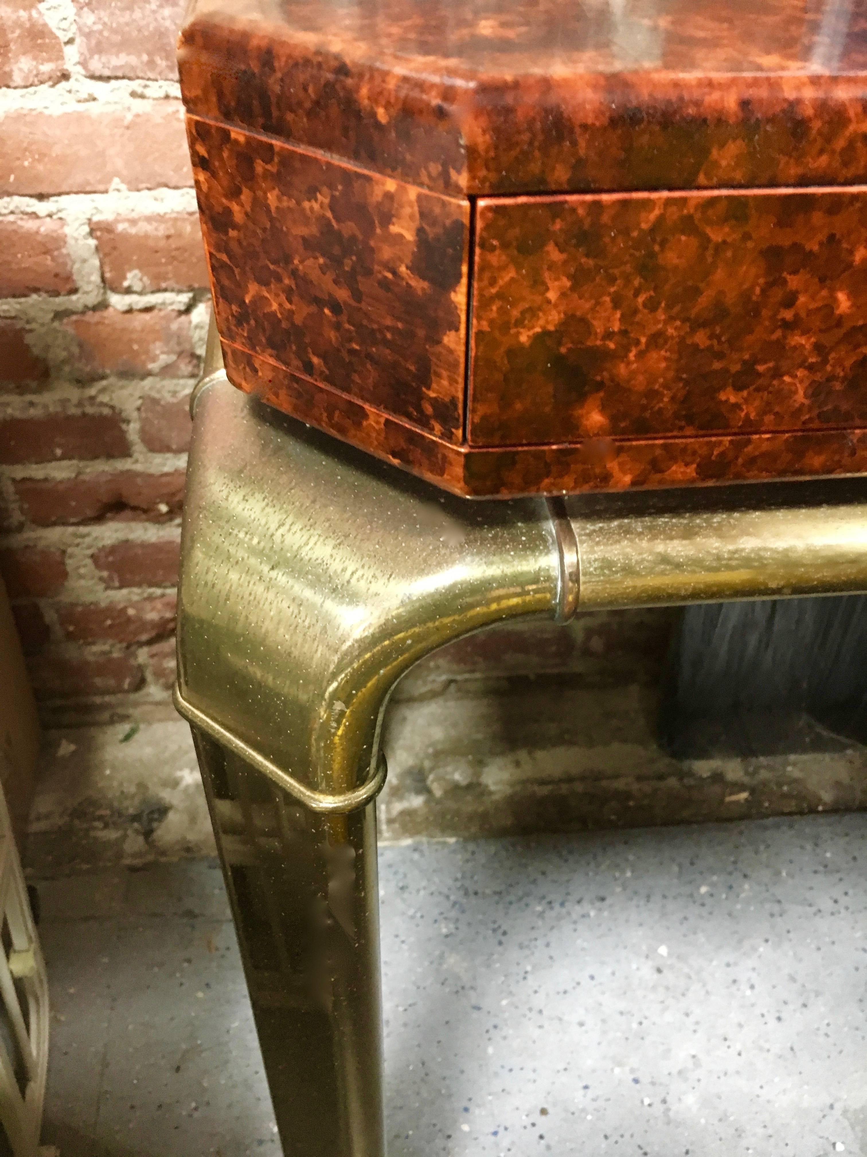 A beautiful brass John Widdicomb console with a red lacquered top with drawers. The finish is original and does need a slight touch up, which will be done prior to shipping, however we are also willing to change the finish to match your project or