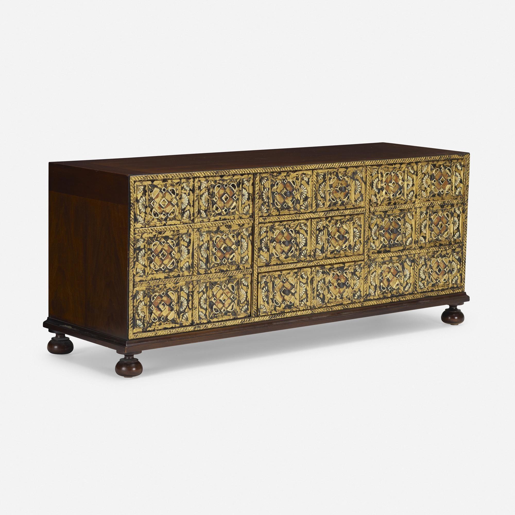 Old world charm meets midcentury....traditional cabinet with carved wood paneled fronts with gilt overlay wash contrasting with medium brown stained sides and top, resting on bun feet. 3 compartments with 2 internal shelves, middle section has 3