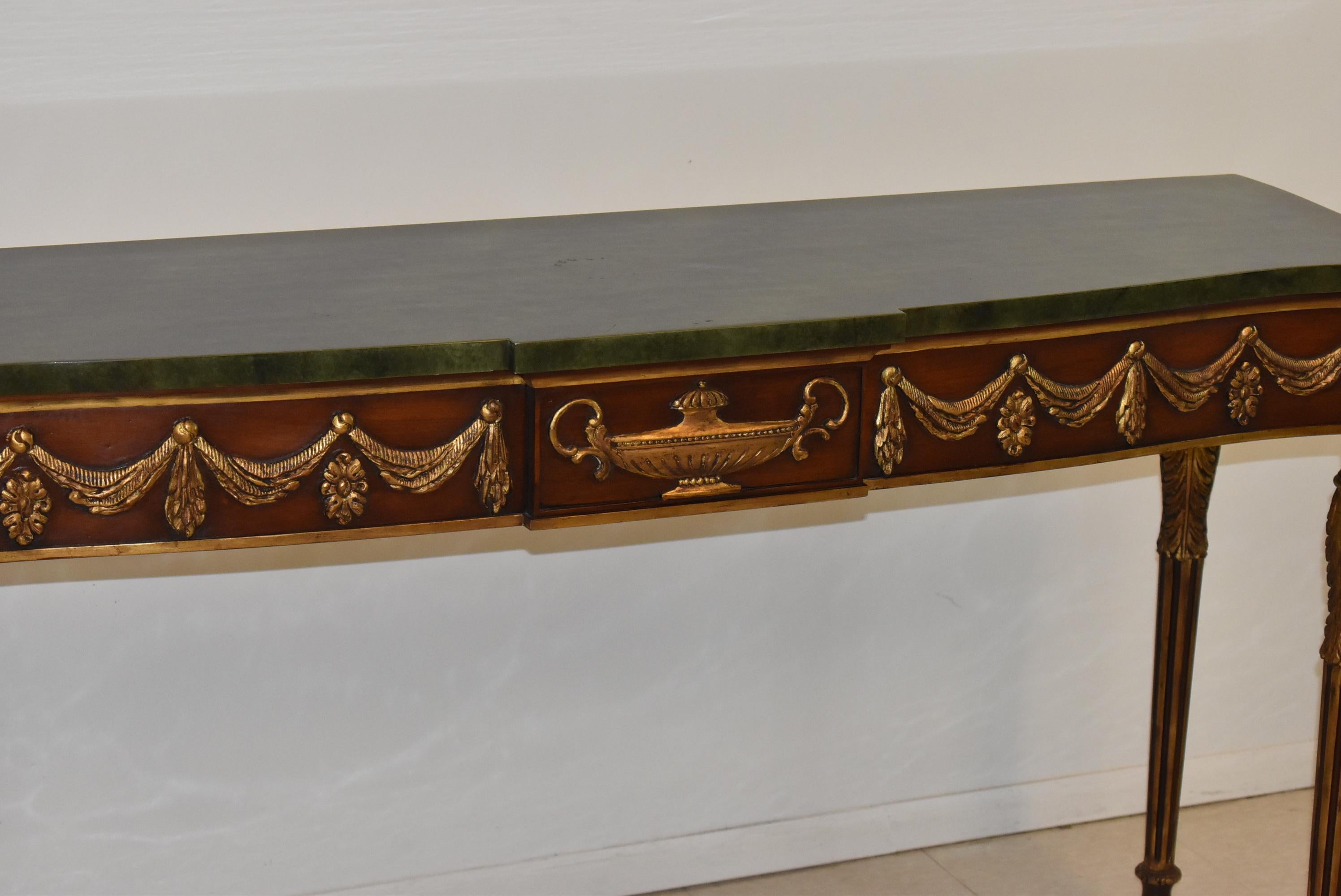 All carved mahogany console table by John Widdicomb. Draped swag details highlighted in gold. Fluted legs have acanthus leaf top designs. Faux marble top that can easily be removed. Very nice condition. Dimensions: 18.5