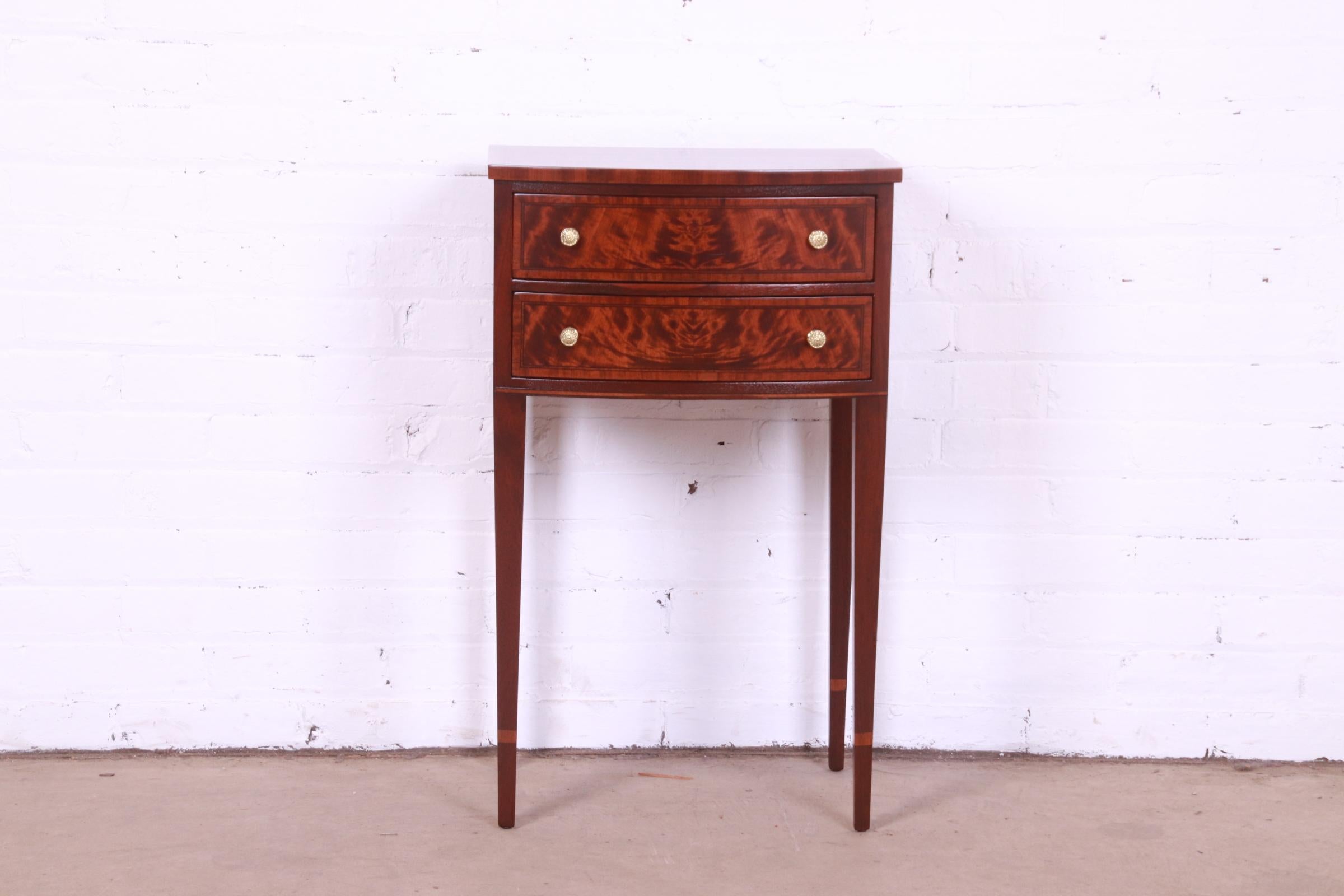 A gorgeous Federal or Hepplewhite style bow front nightstand or side table

By Ralph Widdicomb for John Widdicomb Co.

USA, Circa 1940s

Flame mahogany, with satinwood inlay and original brass hardware.

Measures: 17