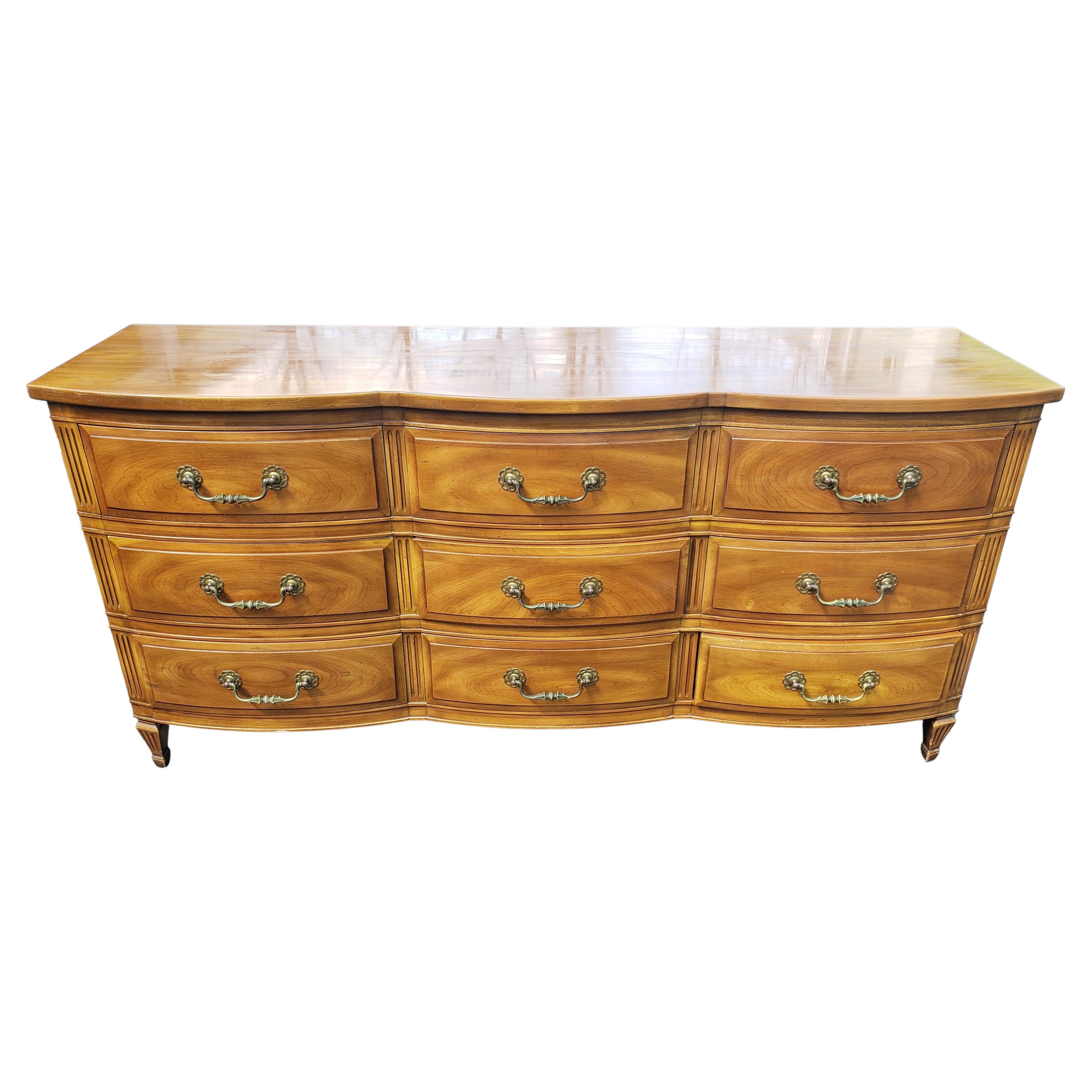 John Widdicomb French Country Serpentine triple Dresser with protective Glass Top,
Serpentine front. Solid wood dovetailed drawers with original heavy duty brass drop pulls. Circa 1950s
Good vintage condition. Top has been protected with loose