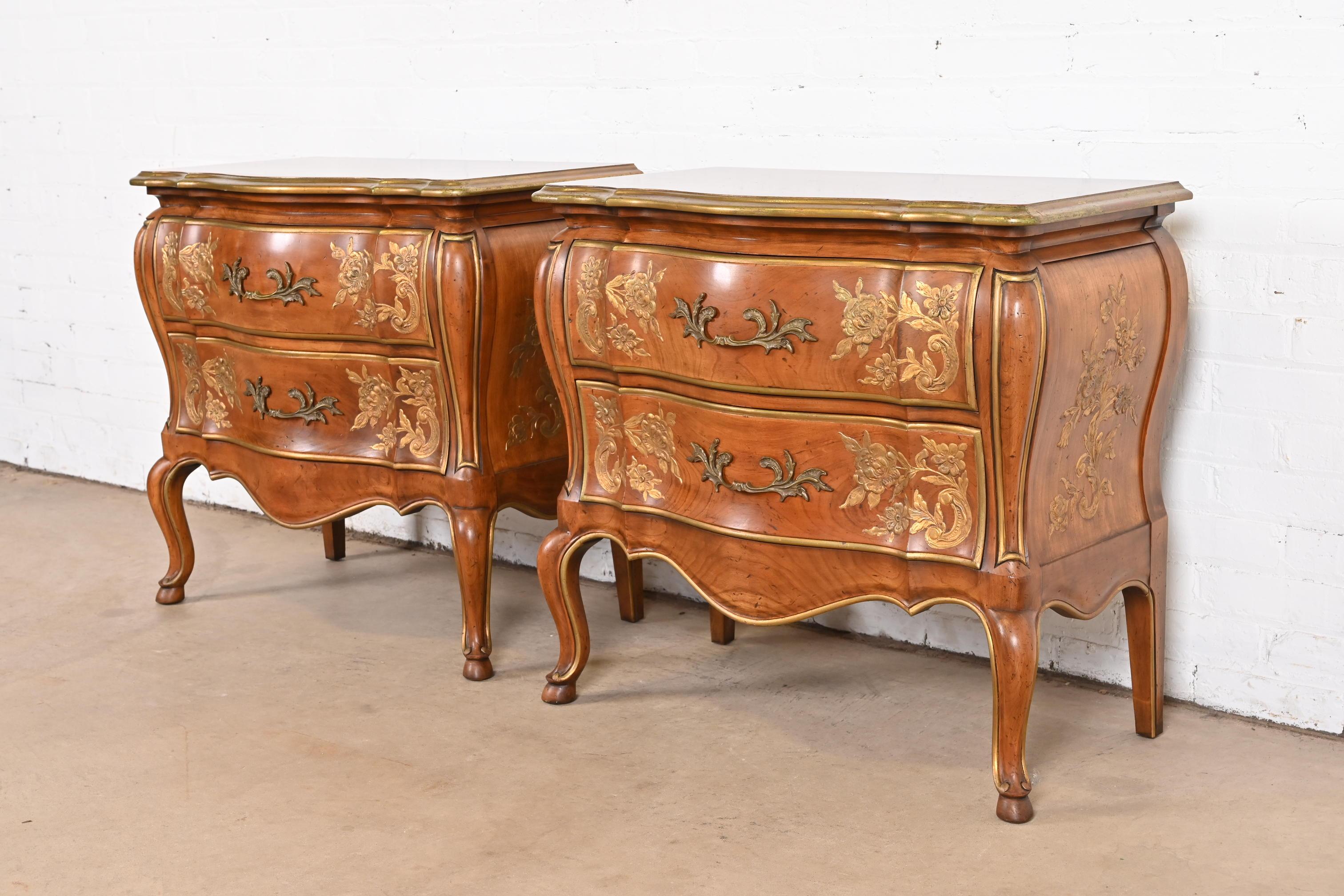 A gorgeous pair of French Provincial Louis XV style bombay form commodes or bedside chests

By John Widdicomb

USA, Circa 1960s

Solid carved cherry wood, with gold gilt trim and floral details, and original brass hardware.

Measures: 30