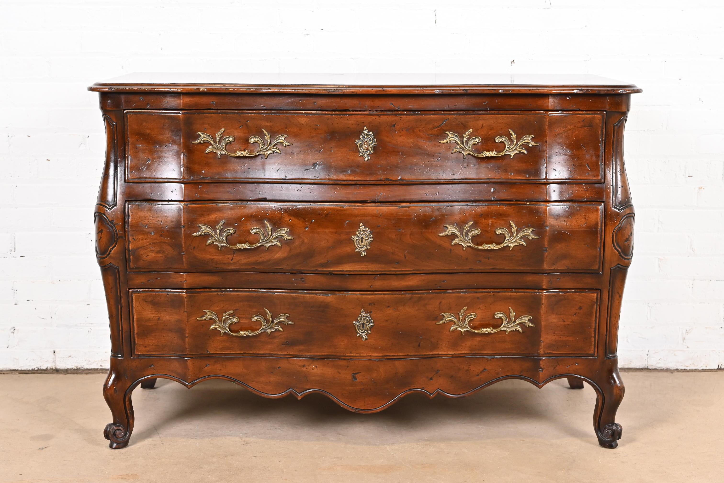 A gorgeous French Provincial Louis XV style carved walnut bombay form dresser or chest of drawers

By John Widdicomb

USA, Circa 1960s

Solid carved walnut, with original brass hardware. Top drawer locks, and key is included.

Measures: 49.25