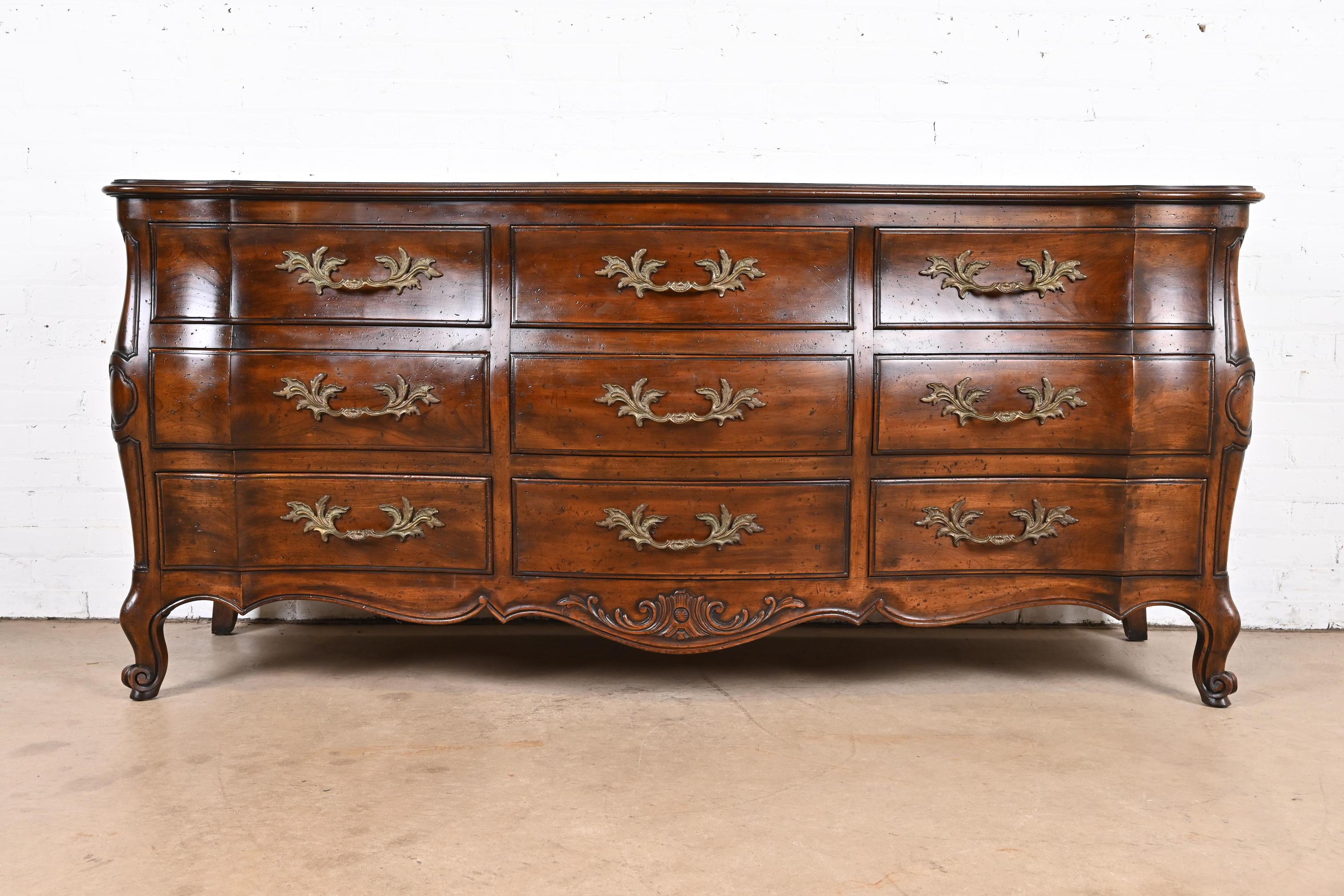 A gorgeous French Provincial Louis XV style carved walnut bombay form long dresser

By John Widdicomb

USA, 1960s

Solid carved walnut, with original brass hardware.

Measures: 74