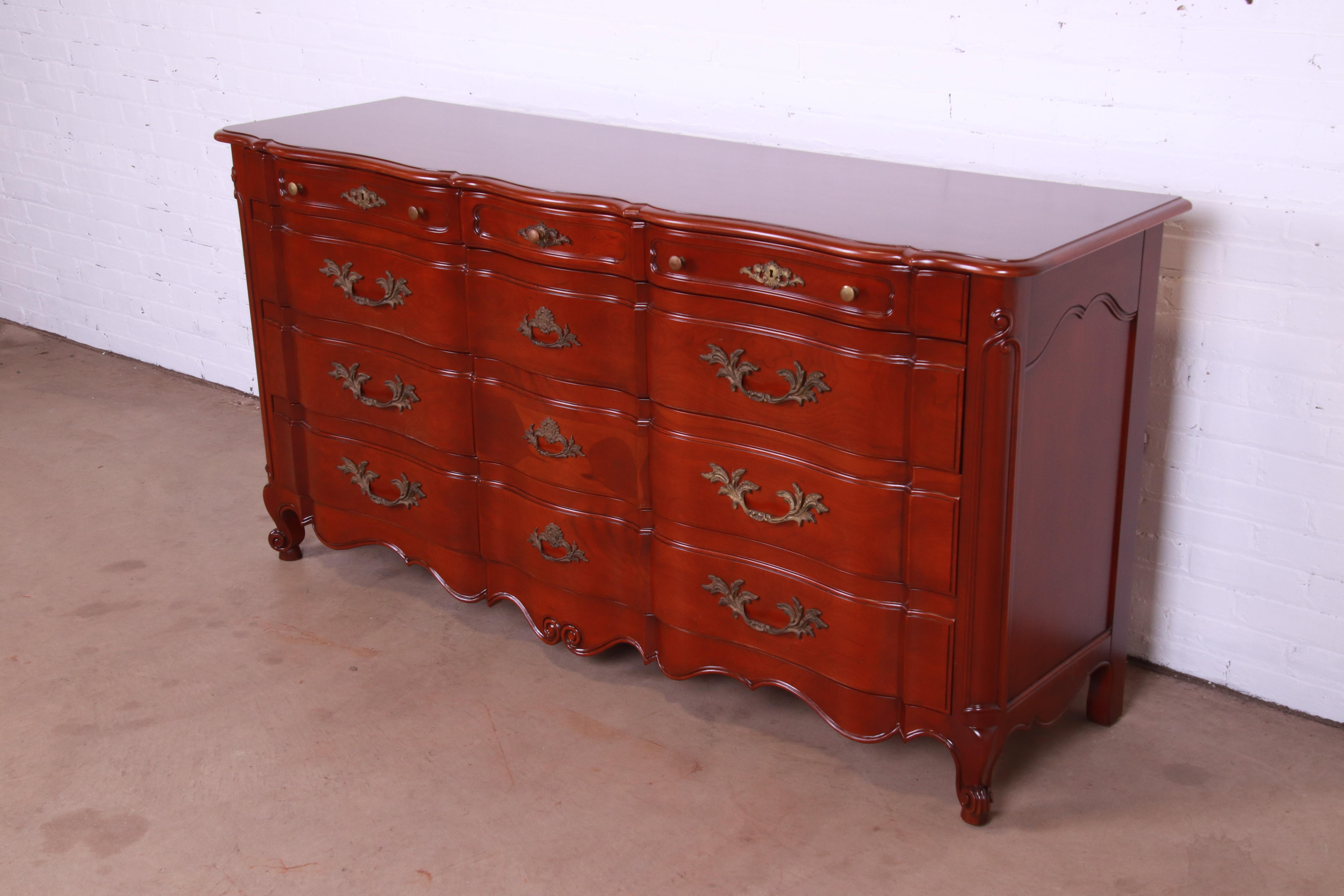 An exceptional French Provincial Louis XV style twelve-drawer dresser or credenza

By John Widdicomb

USA, Circa 1940s

Carved solid cherry wood, with original brass hardware.

Measures: 72.5