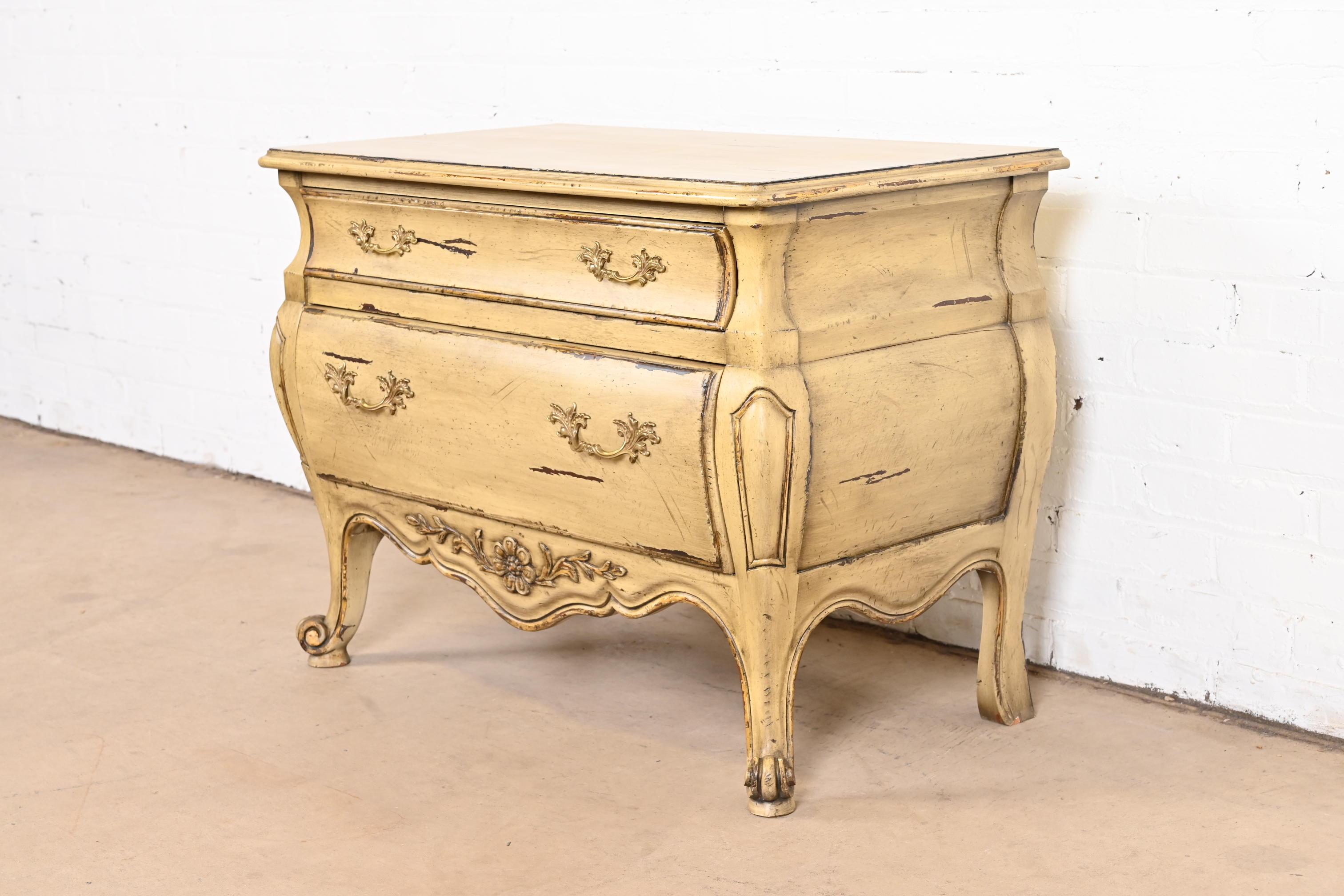A gorgeous French Provincial Louis XV style carved two-drawer commode or bedside chest of drawers

By John Widdicomb

USA, Late 20th Century

Solid carved walnut, with original painted and gold gilt finish and brass hardware.

Measures: 32