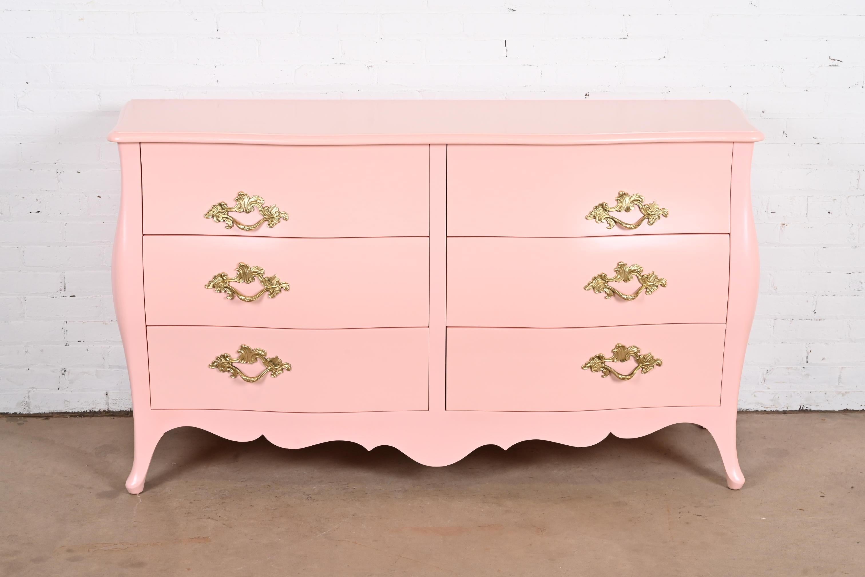 An exceptional French Provincial Louis XV style bombay form six-drawer dresser or chest of drawers

By John Widdicomb

USA, Circa 1940s

Pink lacquered mahogany, with original brass hardware.

Measures: 61.75