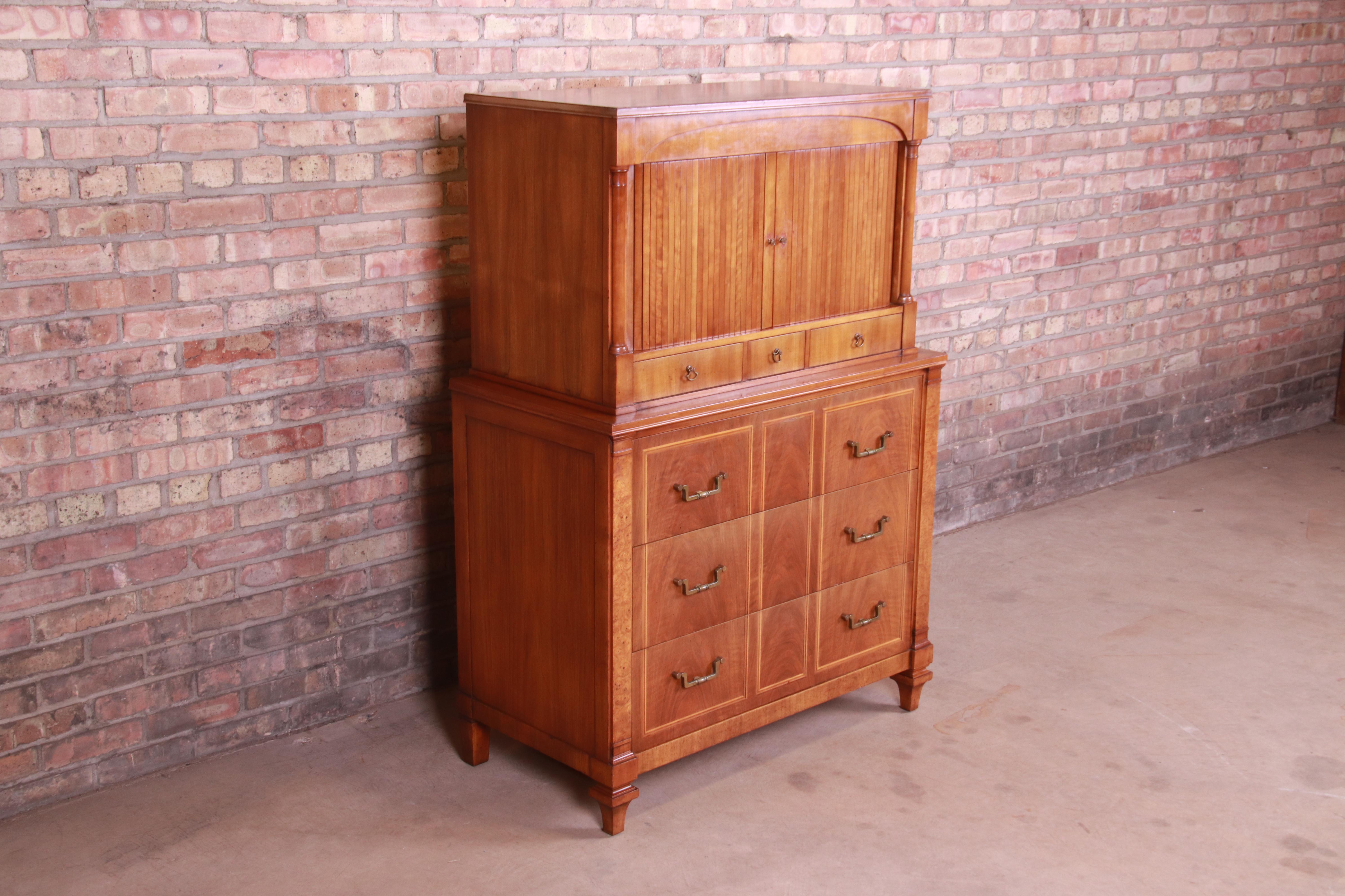 A gorgeous midcentury French Regency style 10-drawer tambour door highboy dresser chest

By John Widdicomb

USA, circa 1960s

Cherry and burl wood, with original brass hardware.

Measures: 38