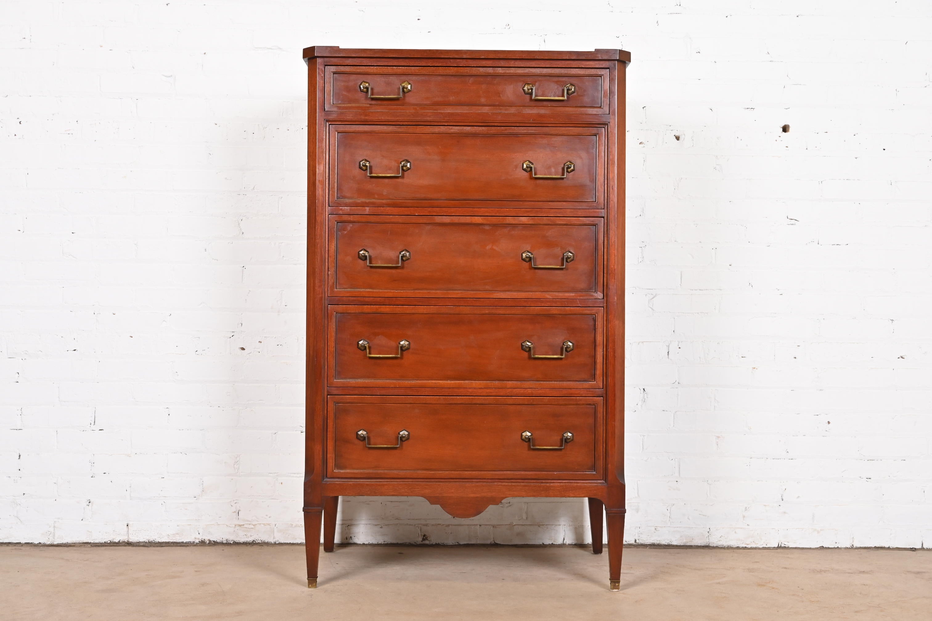 A gorgeous French Regency Louis XVI style five-drawer highboy dresser

By John Widdicomb

USA, Circa 1940s

Carved mahogany, with original brass hardware.

Measures: 32.13